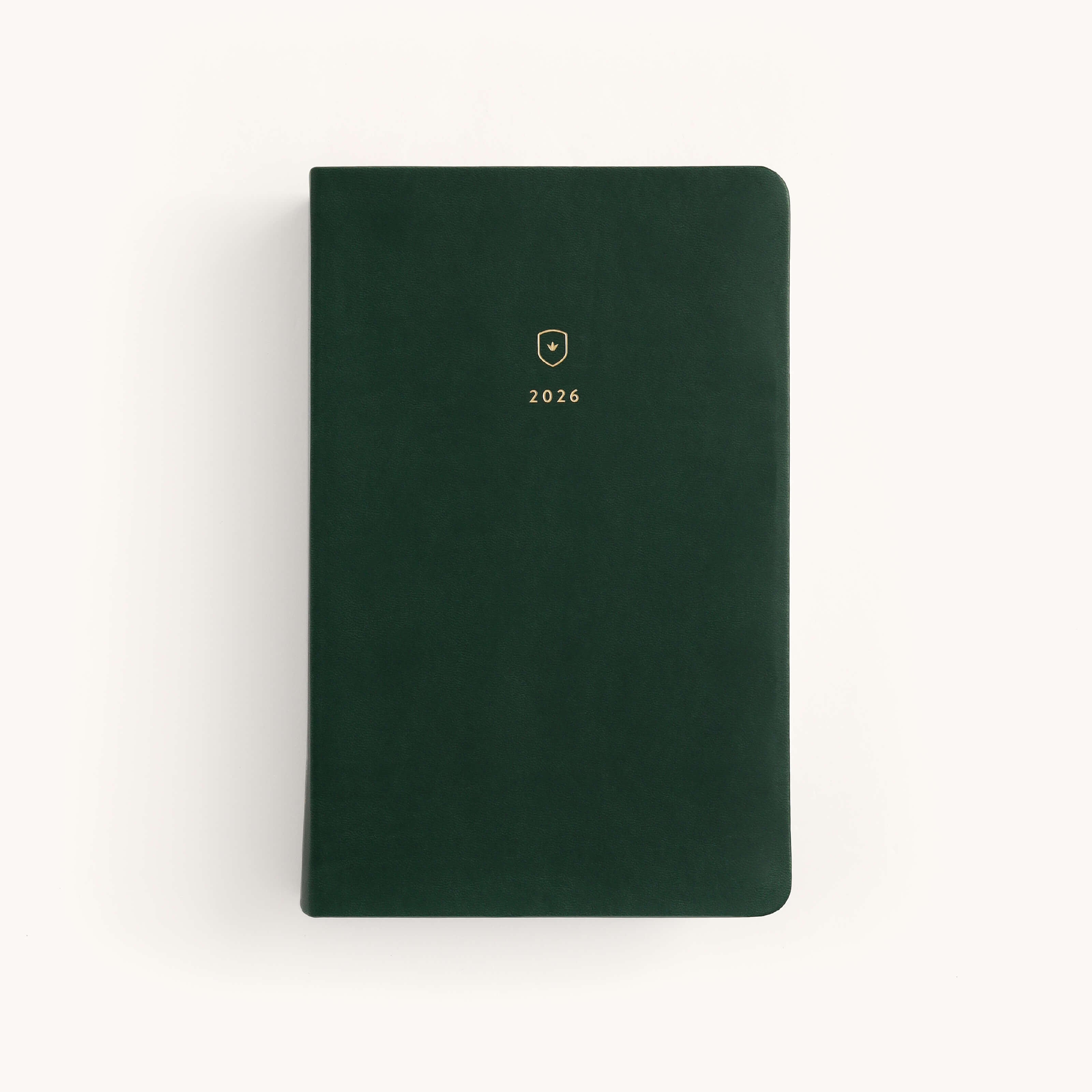 The Simplified 2026 Bookbound Daily Dapperdesk Planner in Evergreen features a leatherette cover, rounded corners, a small gold emblem, and 2026 in gold on the front, shown against a plain white background.