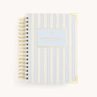 The Simplified 2026 Spiral Daily Simplified Planner in Serene Stripe features a white cover with vertical blue stripes, gold corners, and Daily Simplified Planner in gold.