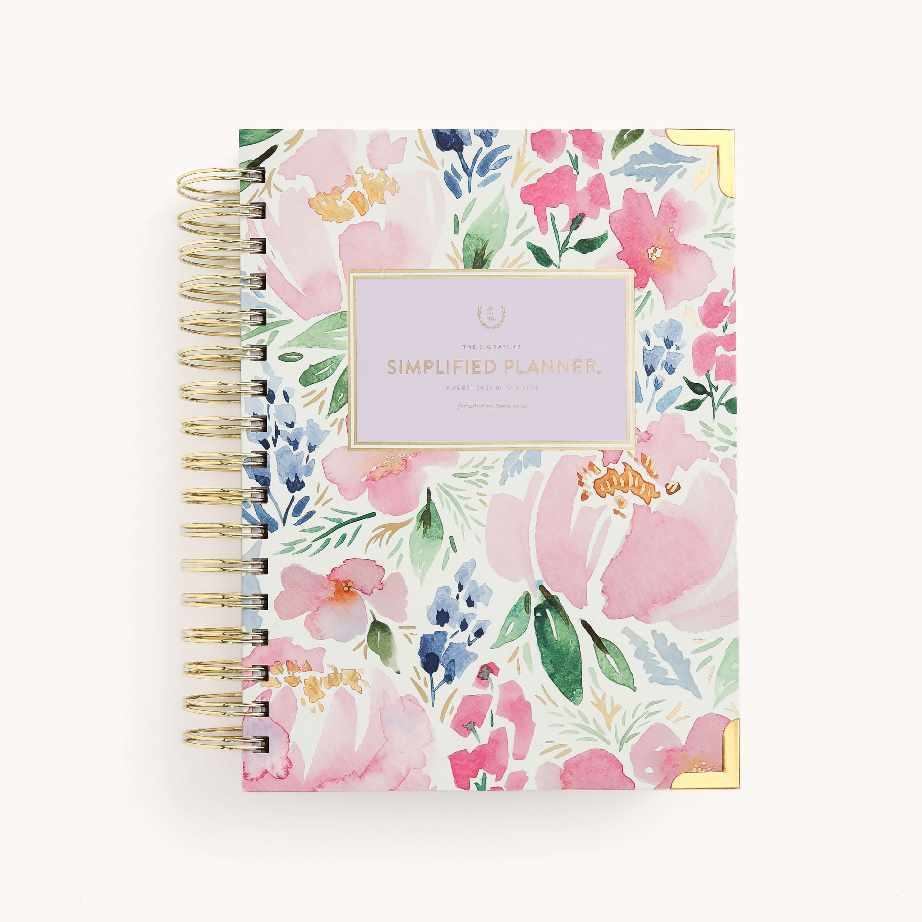 The 2025-2026 Spiral Daily Simplified Planner - Cottage Floral features a vibrant floral cover with pink, blue, and green flowers. It includes a rectangular Simplified Planner label in gold foil on a white background.