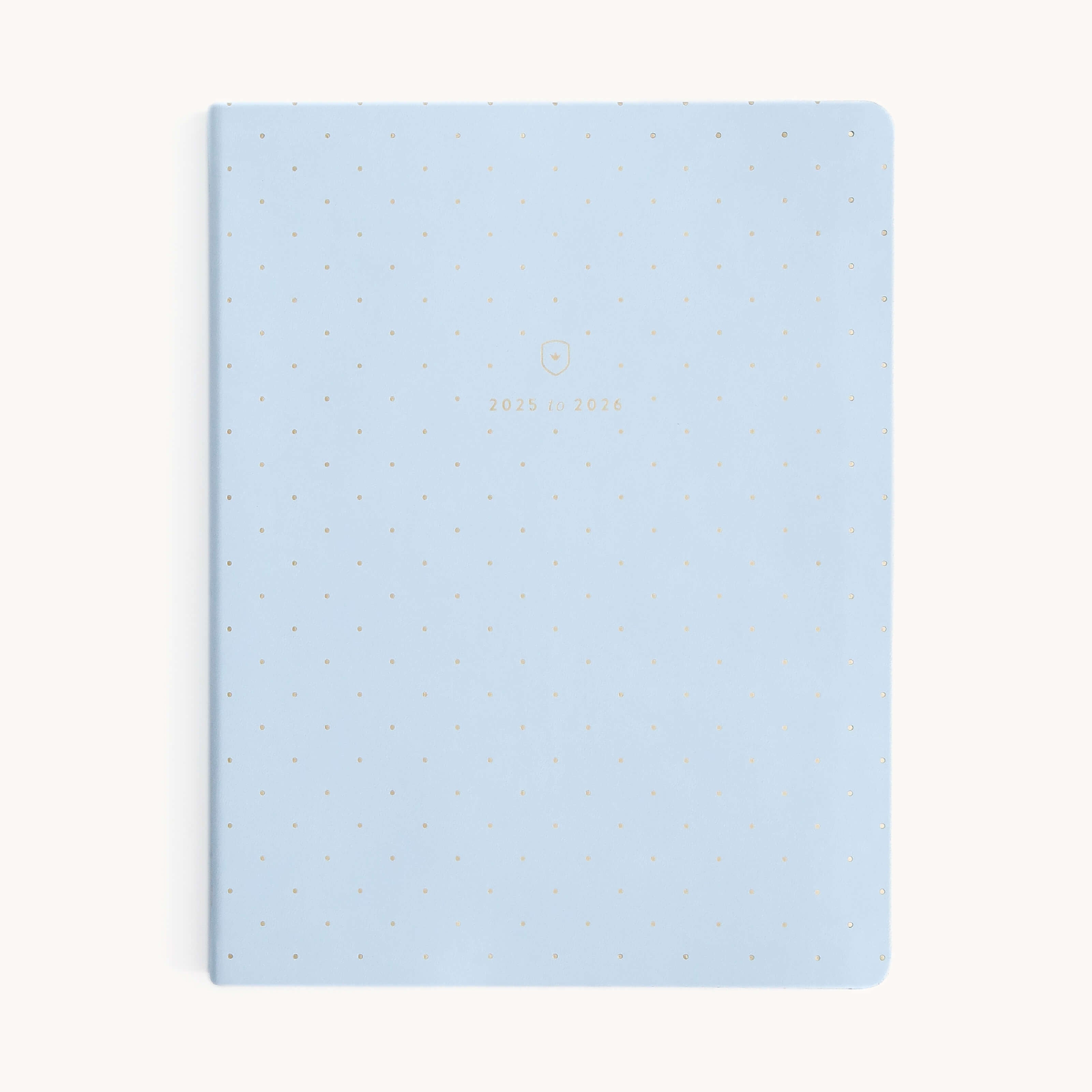 The Simplified 2025-2026 Dapperdesk Planner in Carolina Dot boasts a light blue leatherette cover, featuring subtle polka dots and 2025 to 2026 in small gold letters. This elegant 12-month bookbound weekly planner is perfect for organizing your year with style.
