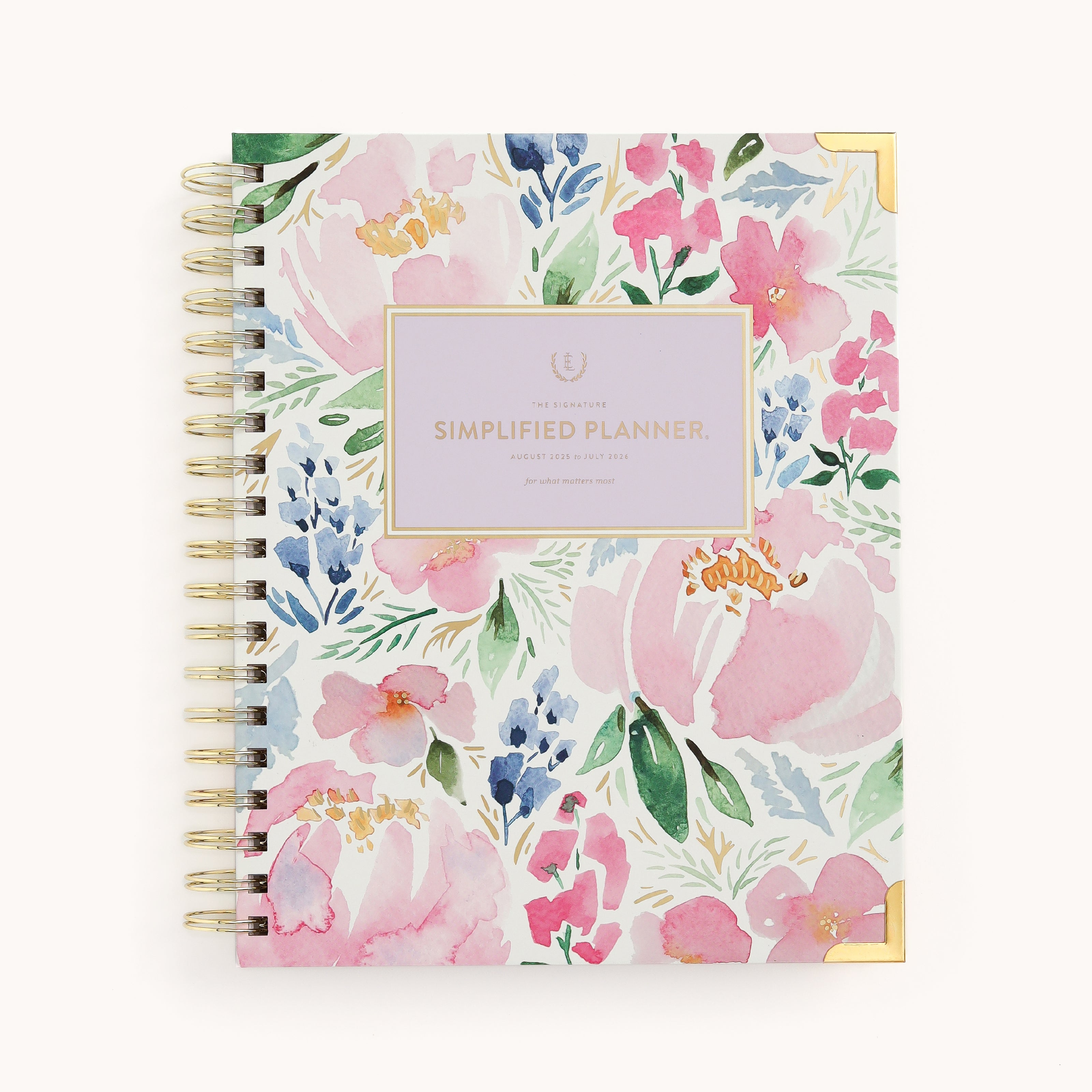 The 2025-2026 Spiral Weekly Simplified Planner - Cottage Floral by Simplified features a floral theme with spiral binding and gold foil accents. The cover displays pink, blue, and green watercolor flowers with Simplified Planner on a central lavender rectangle, ideal for elegant organization.