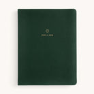 The 2025-2026 Bookbound Weekly Dapperdesk Planner - Evergreen by Simplified features a dark green leatherette cover with rounded corners, 2025 to 2026 gold lettering, and a small gold emblem on the front. It offers a minimalistic design in its 12-month edition.