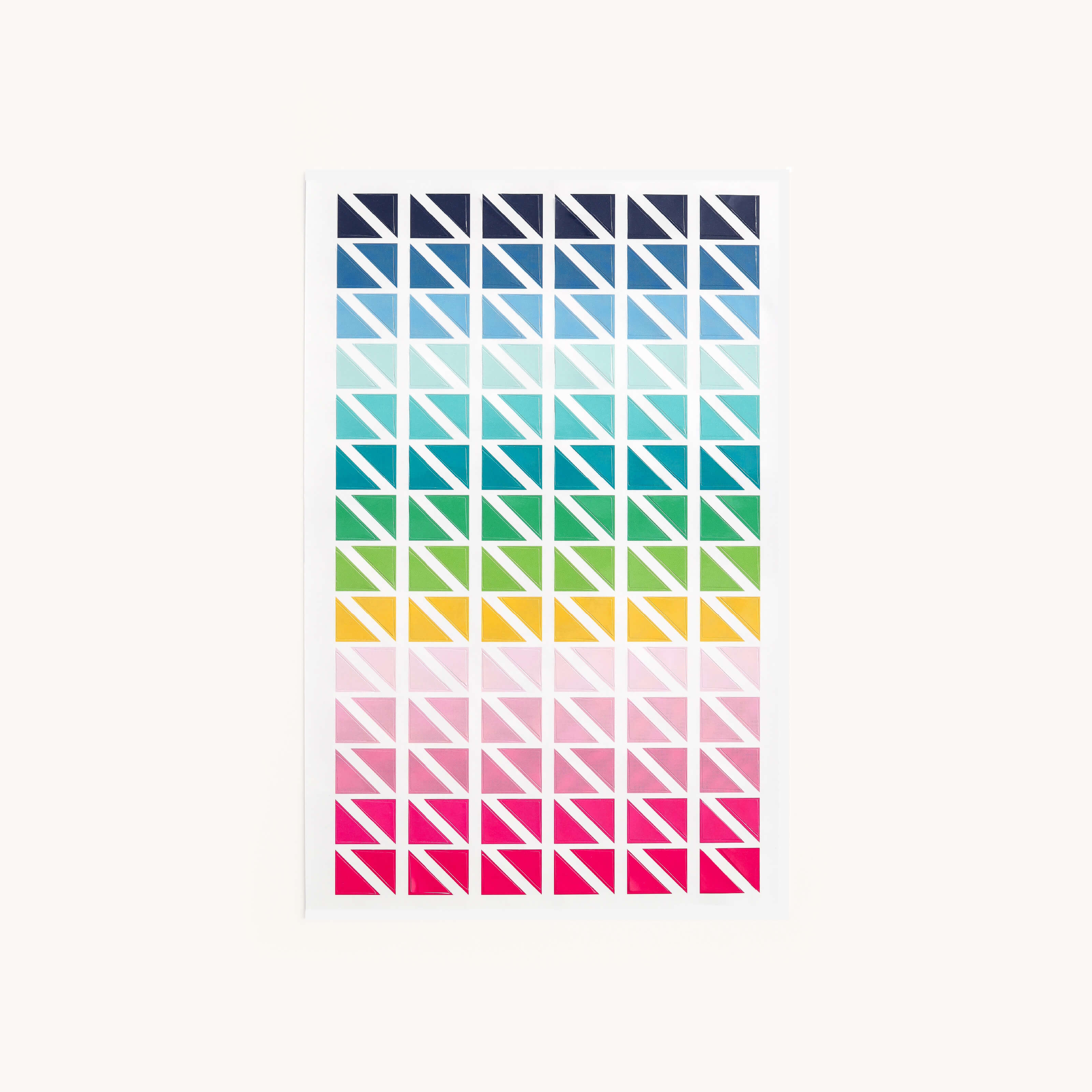 The Simplified Sticker Set - Triangle Corners features rows of colorful triangles in a grid, transitioning from dark blue to teal, green, yellow, pink, and red on white—perfect for color-coding planners or adding fun accents.