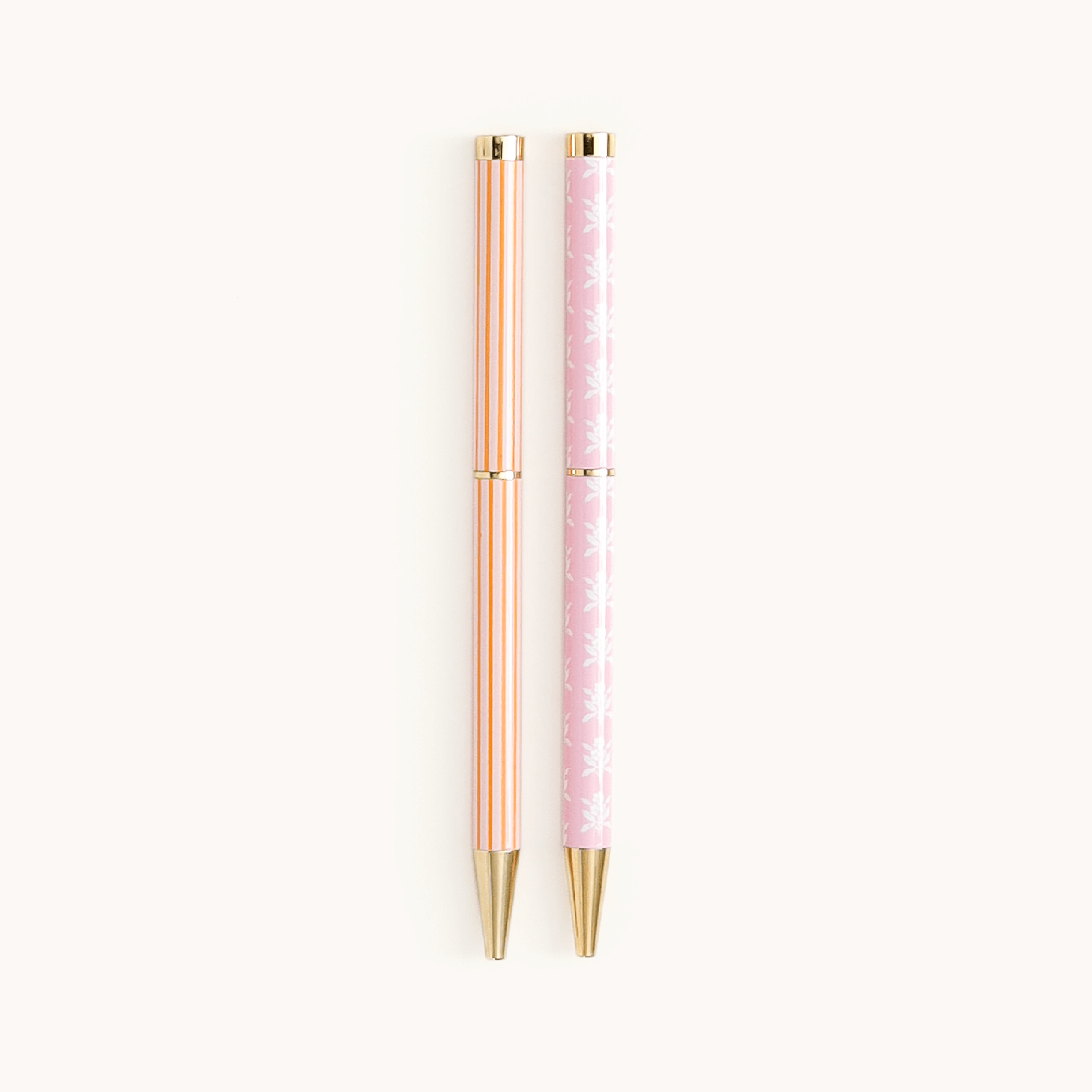 Simplified by Emily Ley | Twist Pen Set featuring two metal pens in Cabana Pinstripe and Blush Block designs. Each pen has a gold twist mechanism.