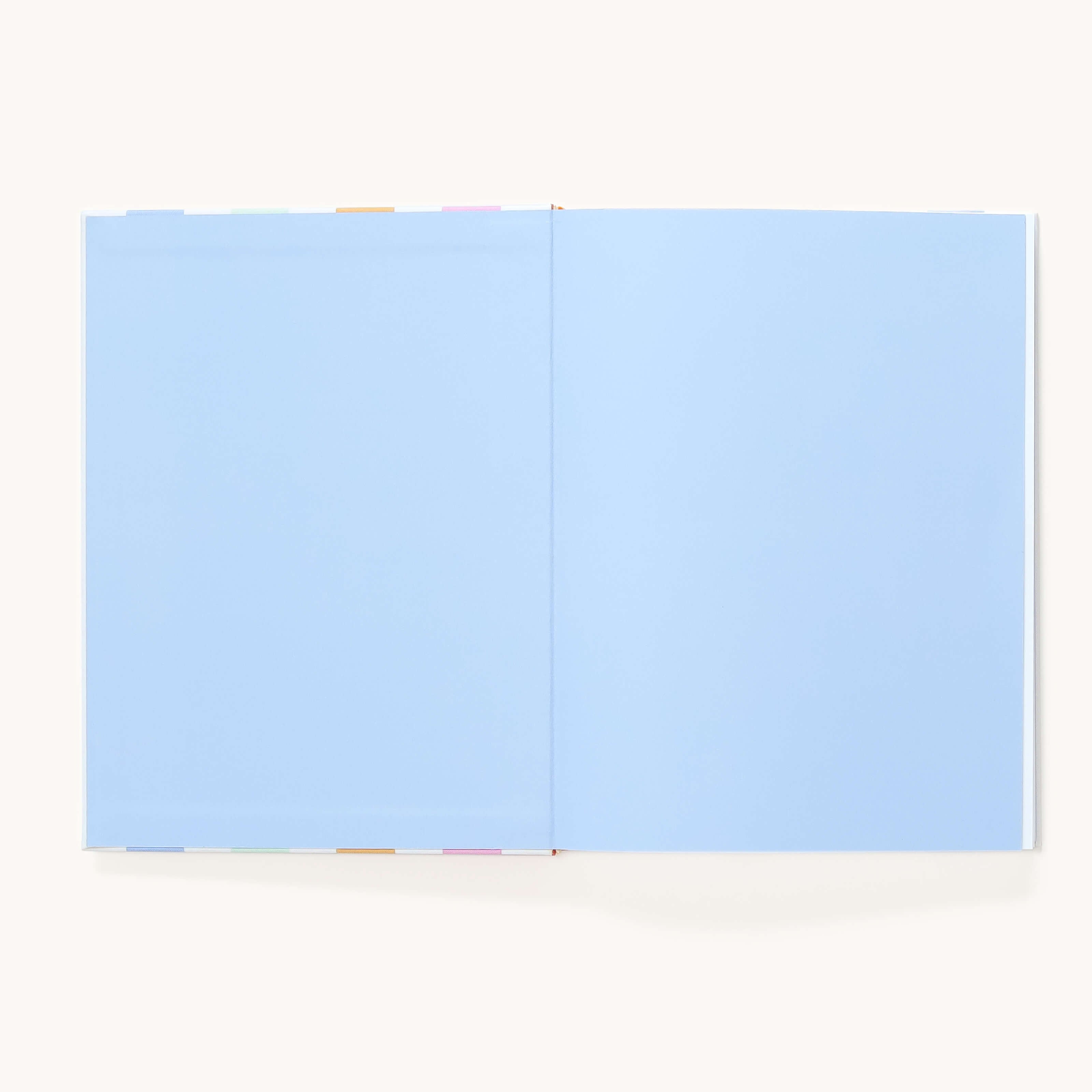The Simplified Linen Journal - Back and Forth features light blue blank pages with multicolored divider tabs, shown open against a plain background—perfect for deepening connection as a back-and-forth journal.