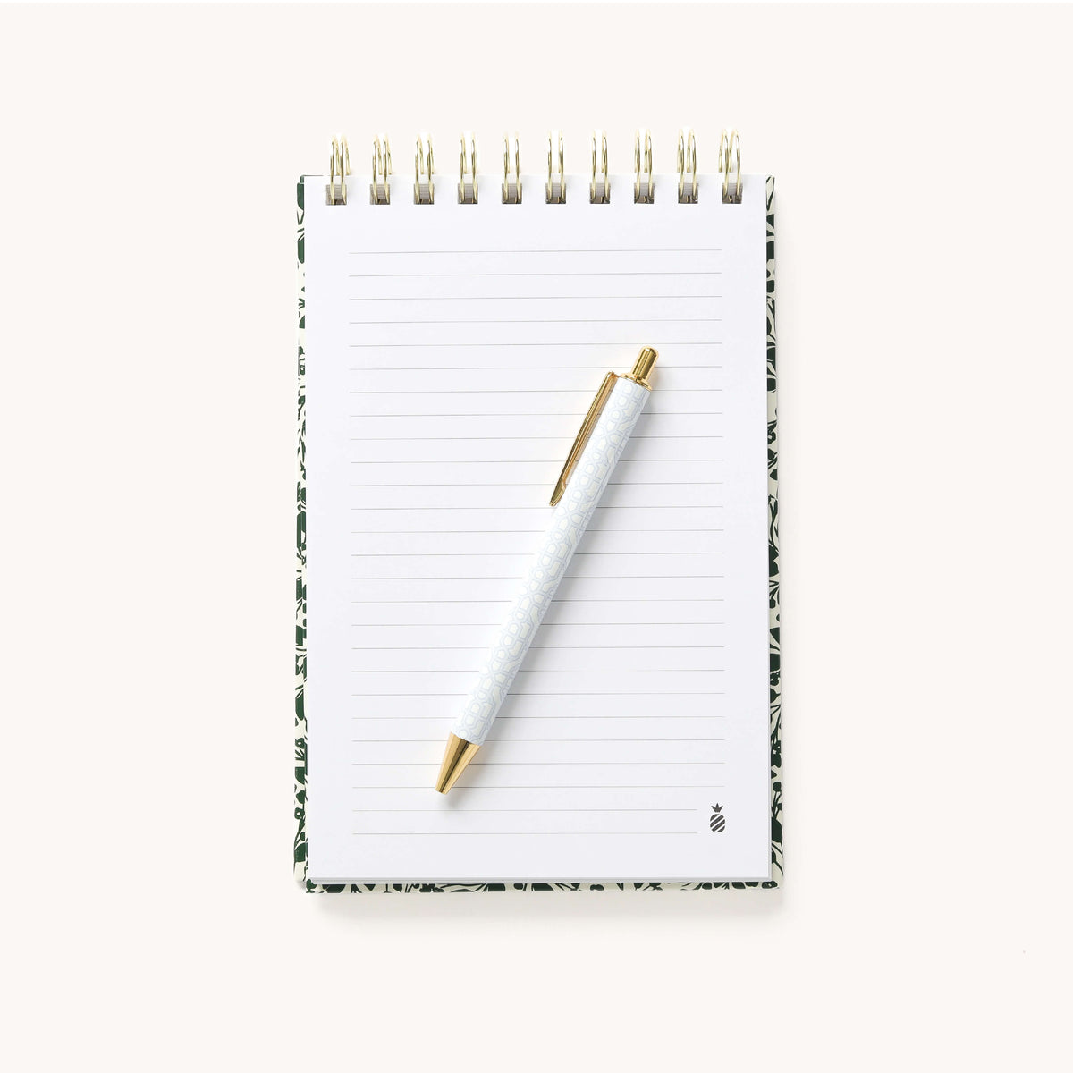 Open blank lined page in the Emerald Floral Top Spiral Notebook with a gold pen