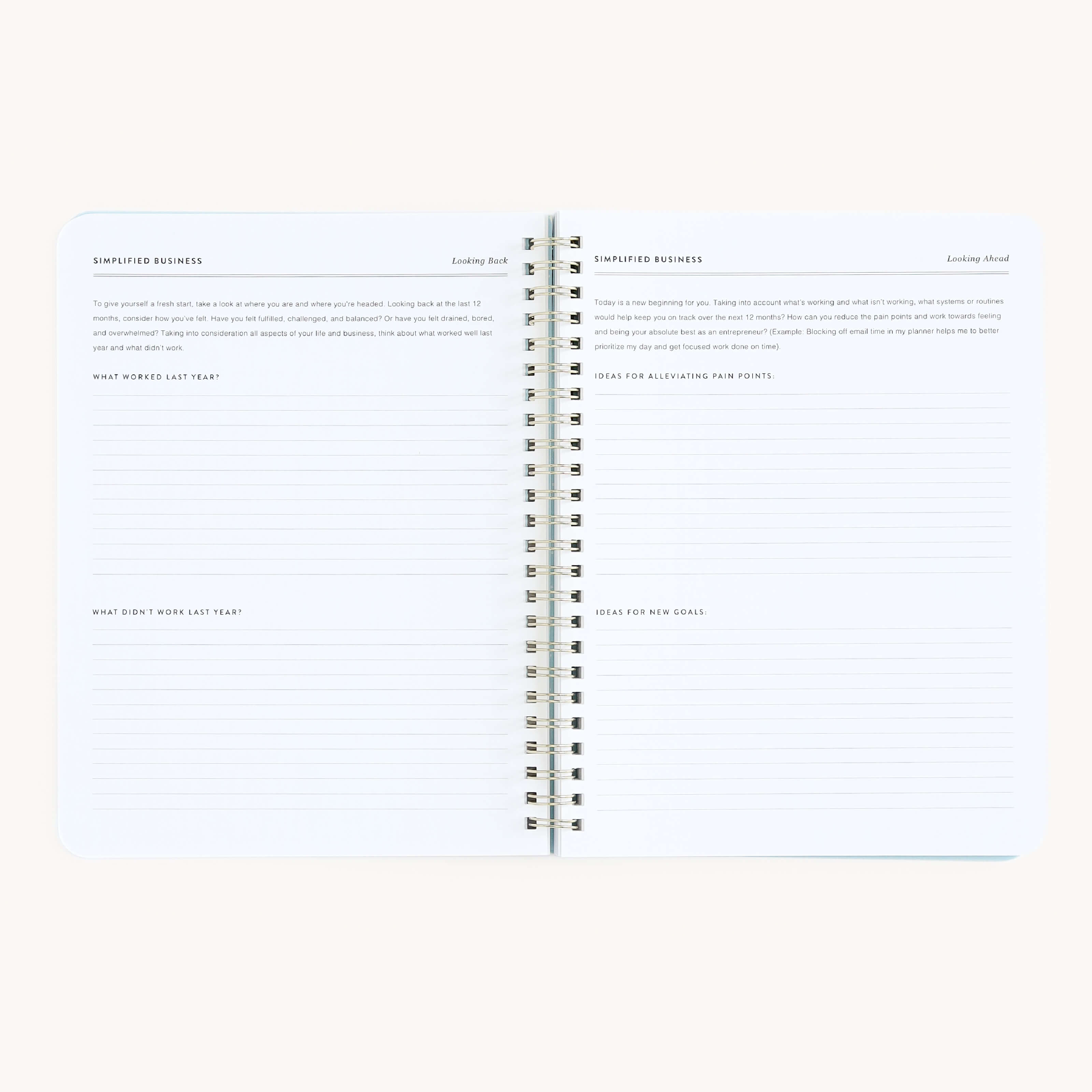 The Simplified Workbook - Entrepreneurship is a spiral-bound notebook with headings: Simplified Business, Looking Back, and Looking Ahead. Its perfect for evaluating past strategies and planning future goals, with lined pages mostly blank for your notes.