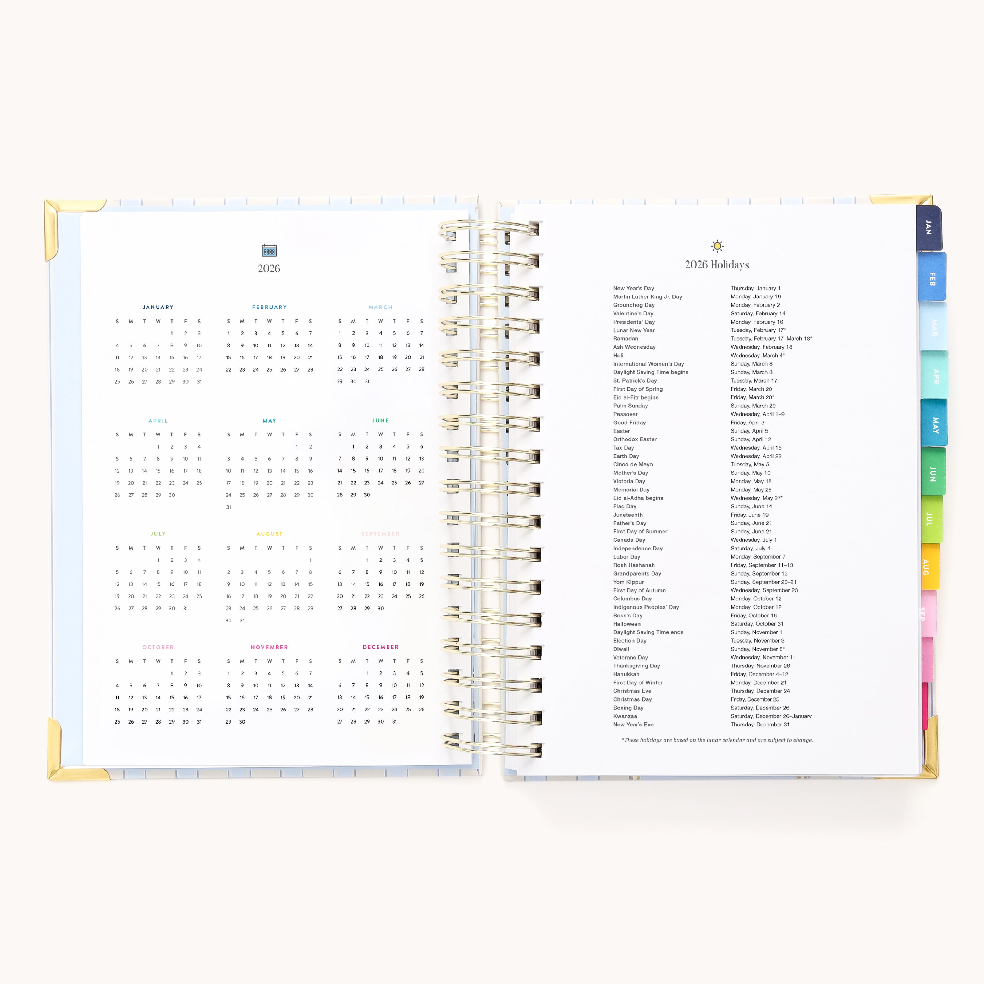 The 2026 Spiral Daily Simplified Planner - Serene Stripe by Simplified features gold metal corners, spiral binding, and colorful tab dividers. Inside, see a 2026 yearly calendar on the left and a holiday list on the right—ideal for planner fans.