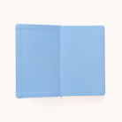 The 2025-2026 Bookbound Daily Dapperdesk Planner by Simplified features an elegant leatherette cover. Its light blue pages and binding are captured from above against a plain white background, highlighting the Carolina Dot design.