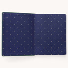 The Simplified 2025-2026 Bookbound Weekly Dapperdesk Planner - Evergreen features a navy blue interior with golden bee icons and a leatherette green exterior. Ideal for organization lovers, this elegant 12-month planner is presented beautifully against a plain white background.