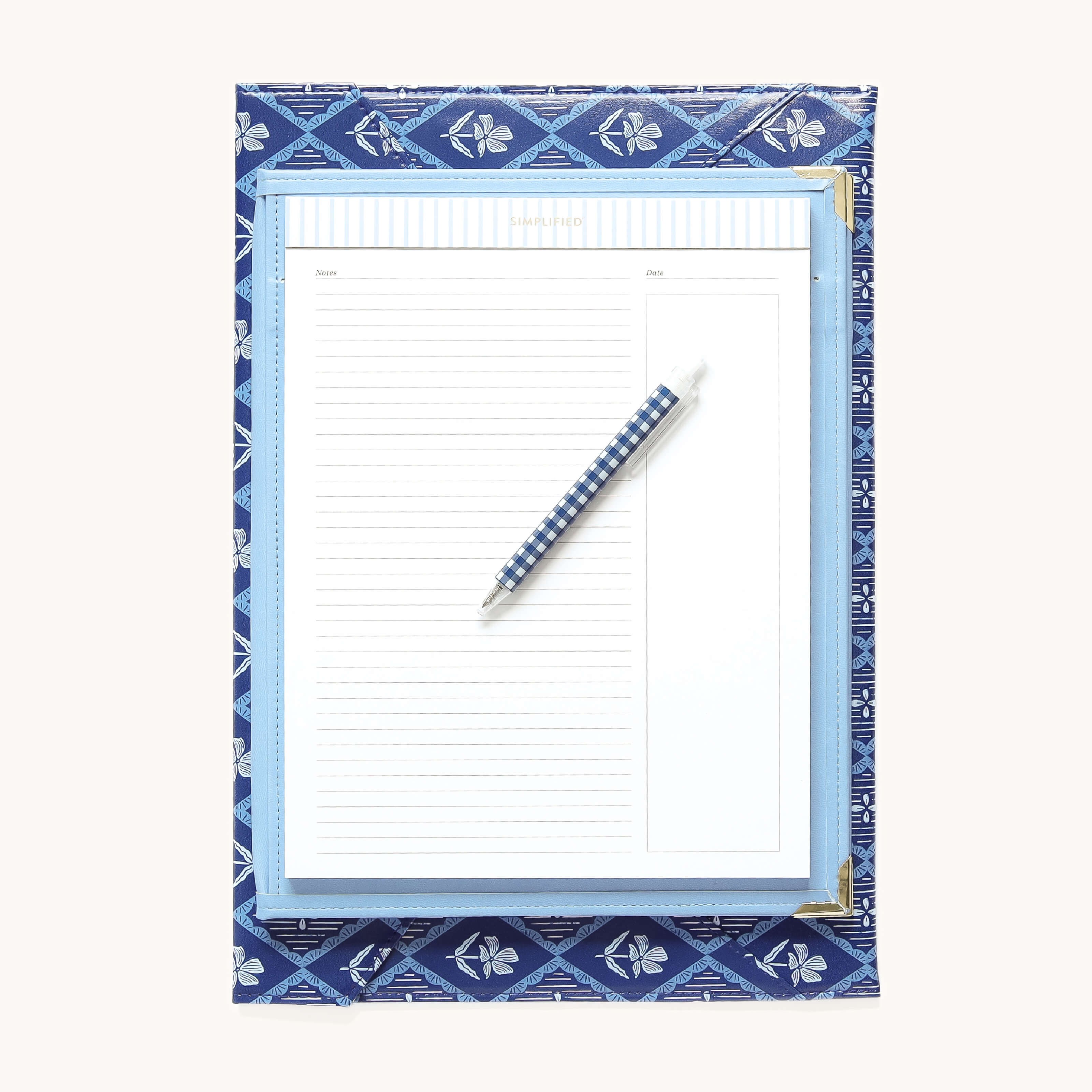 The Simplified Leatherette Folio in French Blue features a blue patterned cover, a removable legal pad, and comes with a matching blue plaid pen displayed diagonally on top, set against a light background.