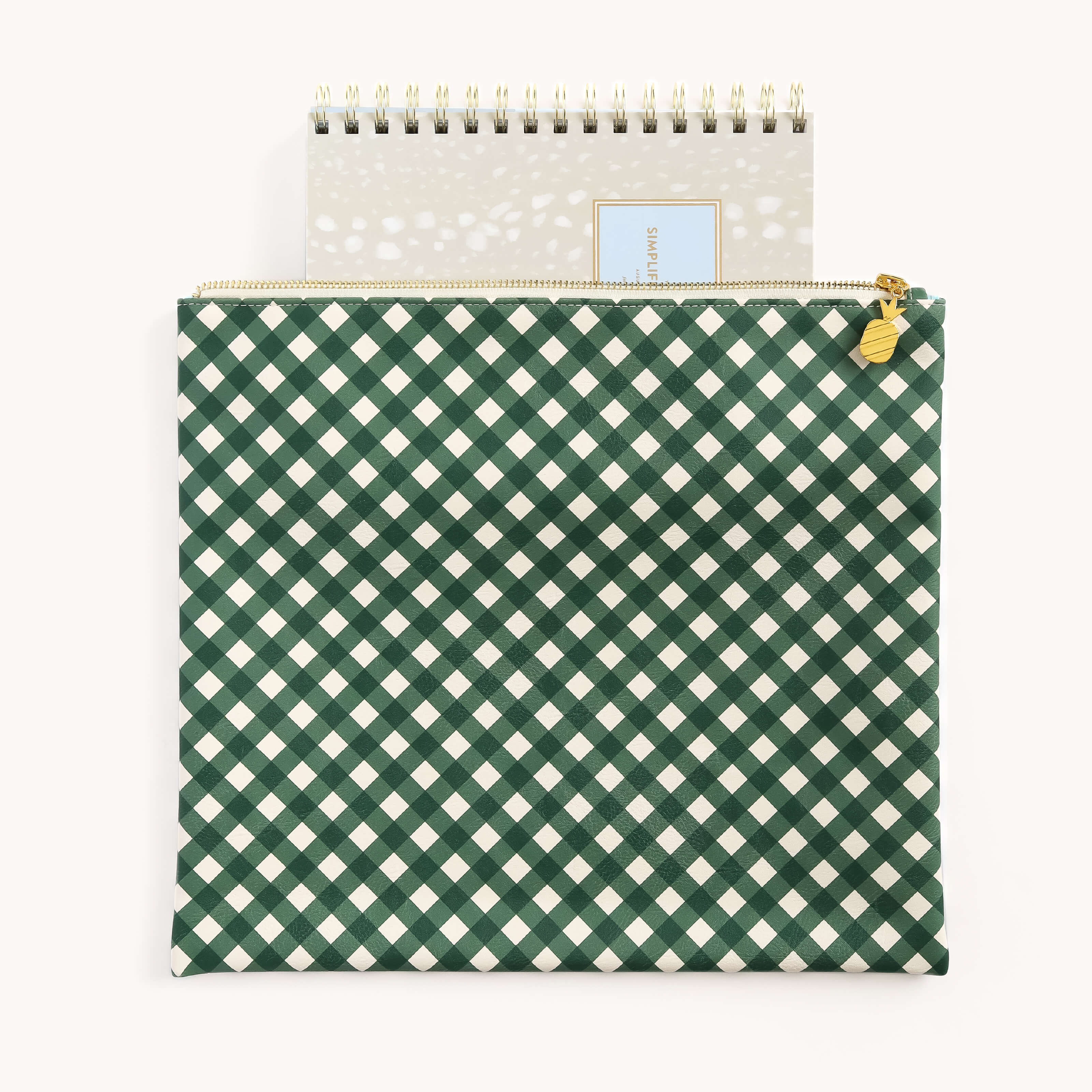 A spiral notebook with a decorative cover peeks out of the Simplified Planner Pouch - Camp Gingham, a stylish storage solution featuring a green and white checkered pattern and a flower-shaped golden zipper pull.