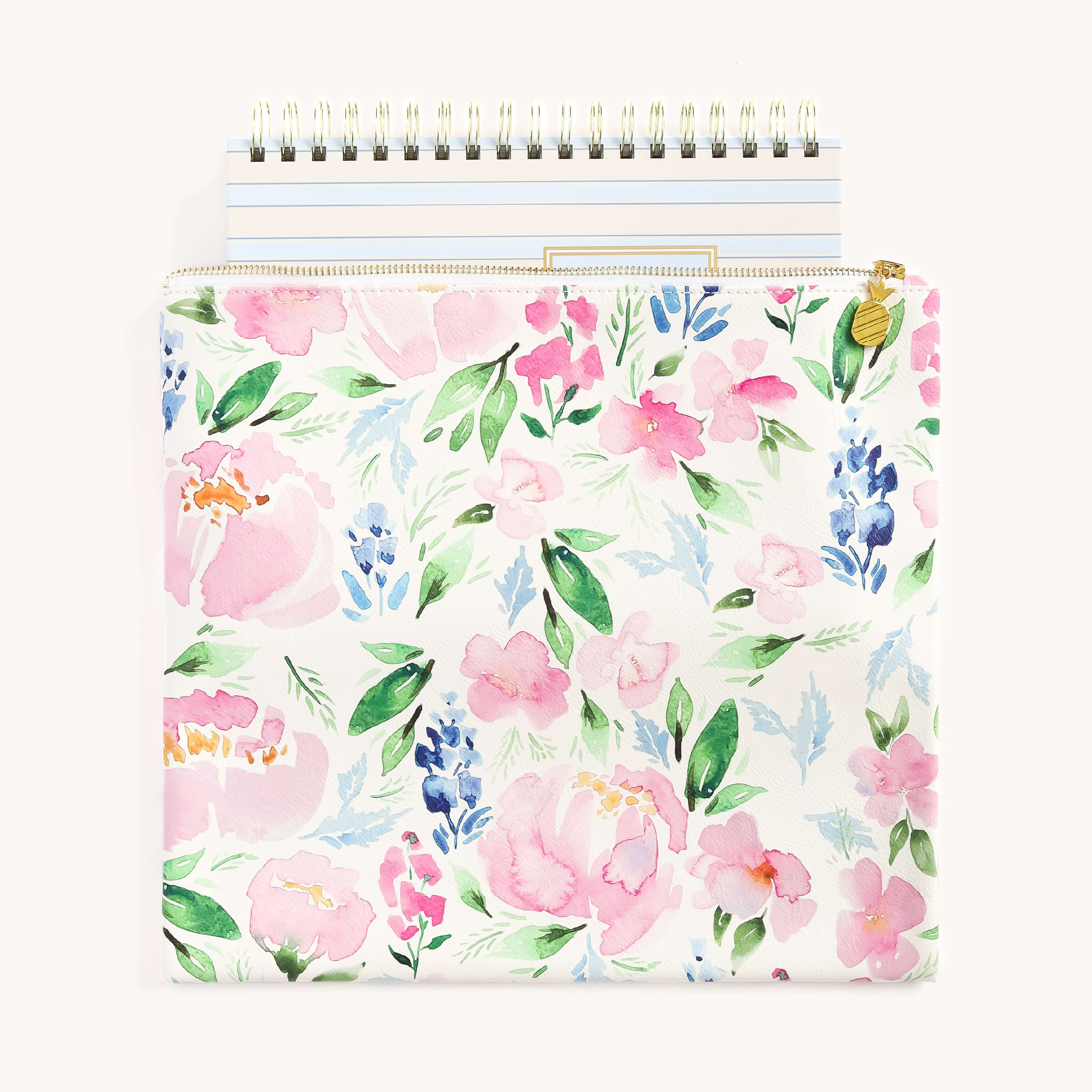 The Simplified Planner Pouch - Cottage Floral stylishly holds a spiral notebook, featuring pink, white, and blue flowers with green leaves on a light background. The notebook has a plain cover with a golden top spiral binding.