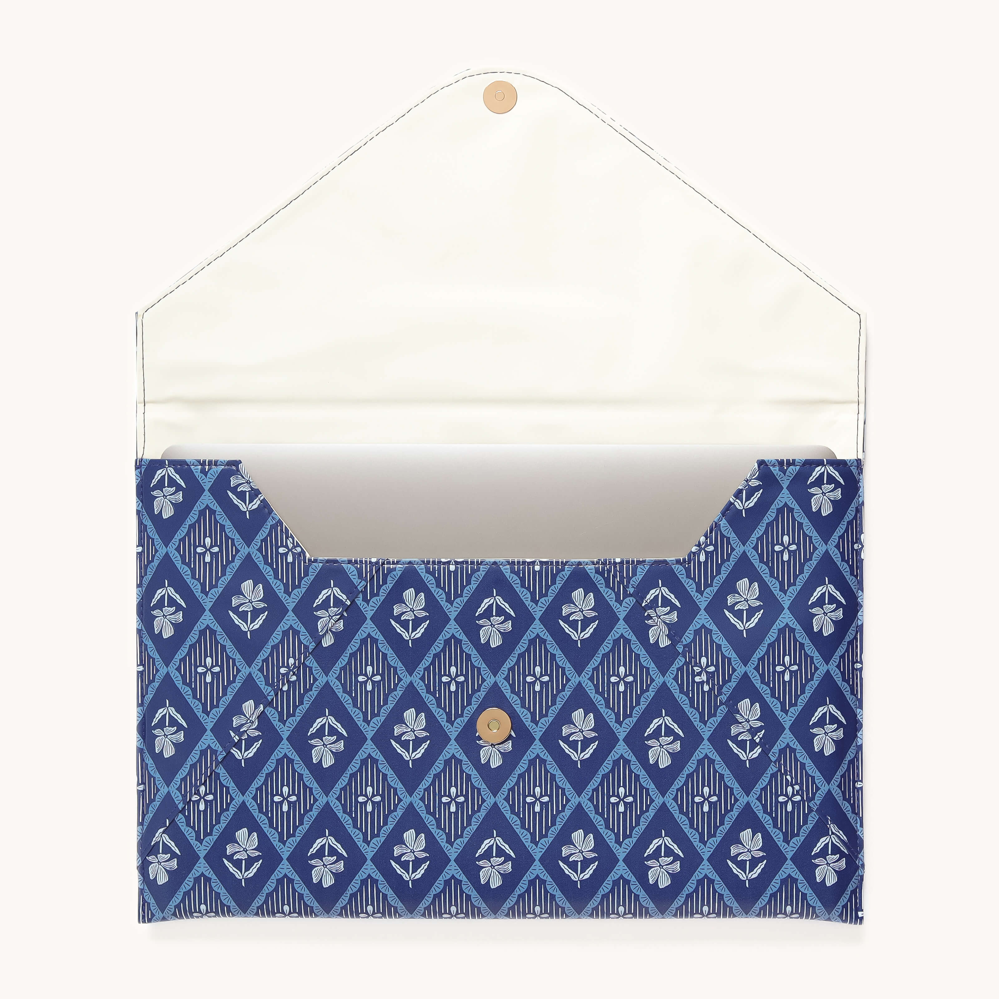 The Simplified Leatherette Tech Case - Block Floral is a blue envelope-style pouch with a white interior, featuring a diamond and floral pattern, central button closure, and an inner pocket.