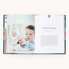 An open book from A Simplified Life by Emily Ley displays a young boy putting a coin into a piggy bank beside Chapter 5, Simplified Finances: Getting a Handle on Money, featuring practical tips for intentional living, with text starting below the chapter title.