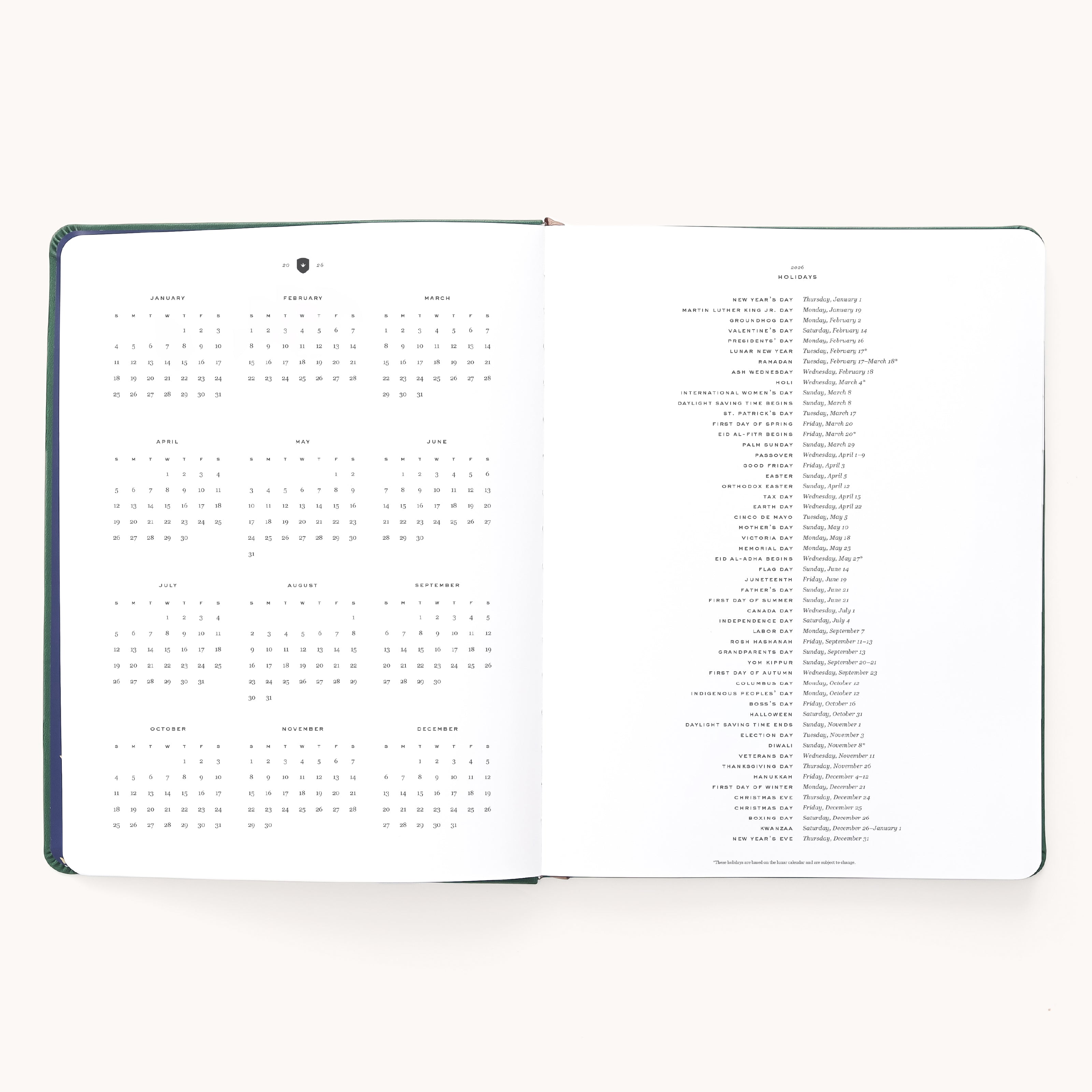 The Simplified 2026 Bookbound Weekly Dapperdesk Planner in Evergreen features a leatherette cover, with a yearly calendar on the left and holidays on the right, both in black text on crisp white pages.