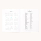 The 2025-2026 Softcover Monthly Simplified Planner by Simplified has a clean, minimal layout with a 12-month grid format for 2025 on the left and holidays for 2025-2026 on the right. It features black text on a white background to emphasize organization.