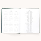 The 2025-2026 Bookbound Weekly Dapperdesk Planner - Evergreen by Simplified features a yearly calendar with months in a grid on the left, international holidays listed vertically on the right, and a sleek leatherette cover—all against a plain white background.