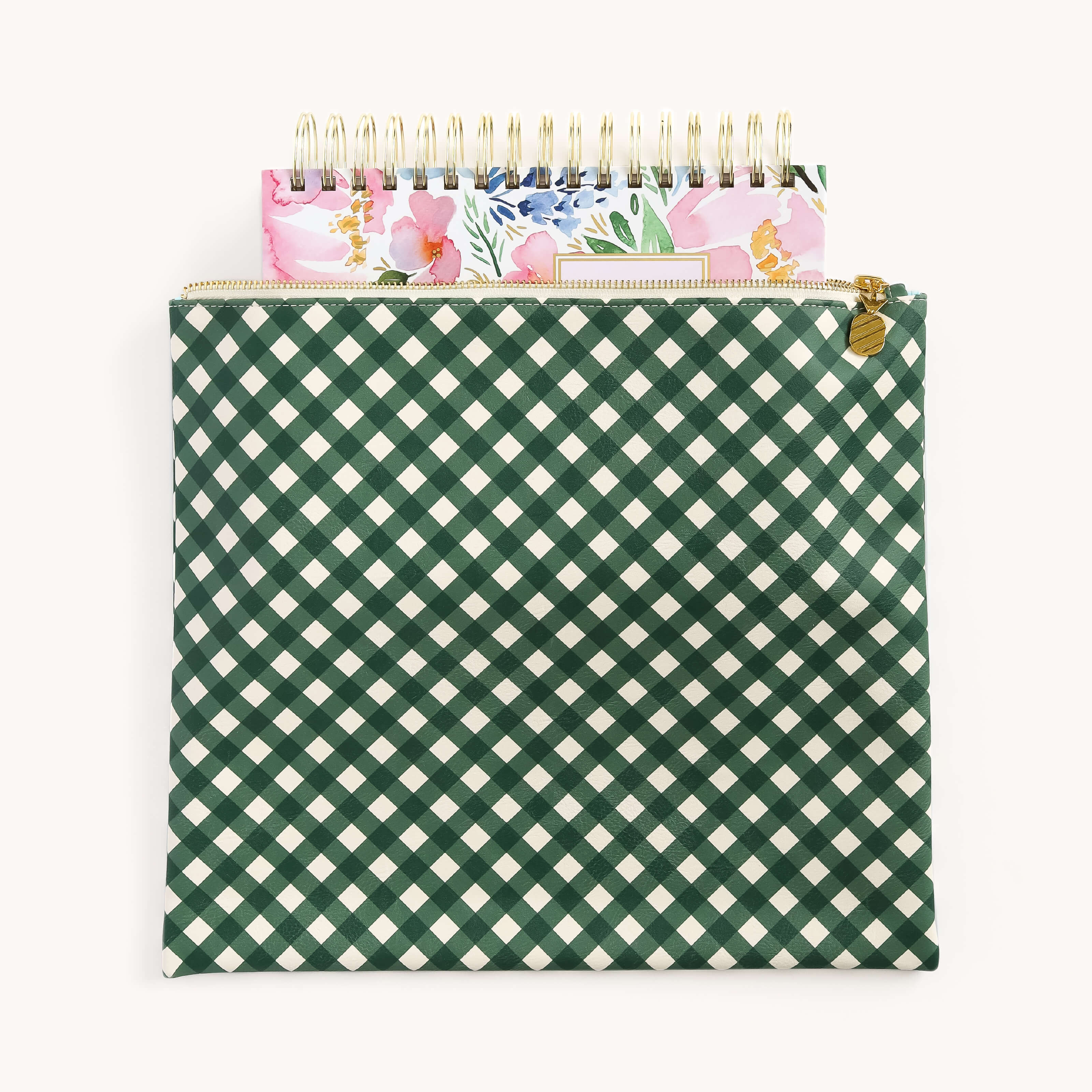 The Planner Pouch - Camp Gingham by Simplified offers a stylish storage solution with its green and white checkered leatherette exterior and gold zipper, partially opened to reveal a floral-patterned spiral-bound notebook inside.