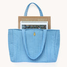 A Weekly Simplified Planner, Daily Simplified Planner, and Weekly Dapperdesk Planner peeking out of a Quilted Tote Bag in French Blue.