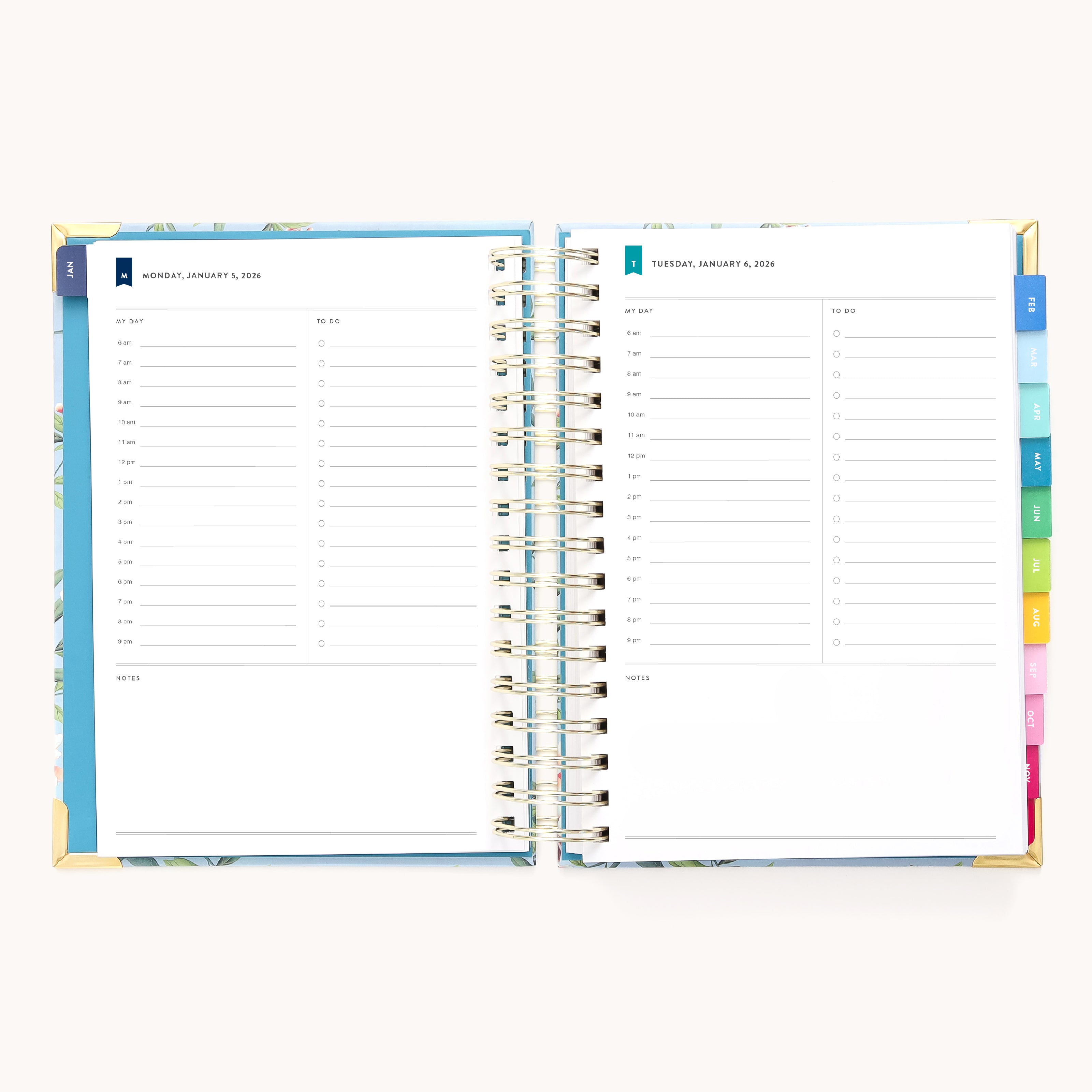 The 2026 Spiral Daily Simplified Planner - Faraway Land by Simplified features open daily pages with time slots from 7 a.m. to 8 p.m., to-do lists, notes sections, vibrant tab dividers, and a hand-painted cover pattern on the right side.
