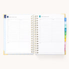 The 2026 Spiral Daily Simplified Planner - Serene Stripe by Simplified features an open spiral layout with two days per spread, hourly lined sections from 7 AM to 8 PM, note space, and colored tab dividers on the right.