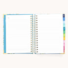 The 2025-2026 Spiral Daily Simplified Planner - Faraway Land features a decorative blue border with gold foil on the cover. The right side has colorful tab dividers labeled for organization, while the left page is marked Notes, providing an organized look akin to a Simplified Planner.