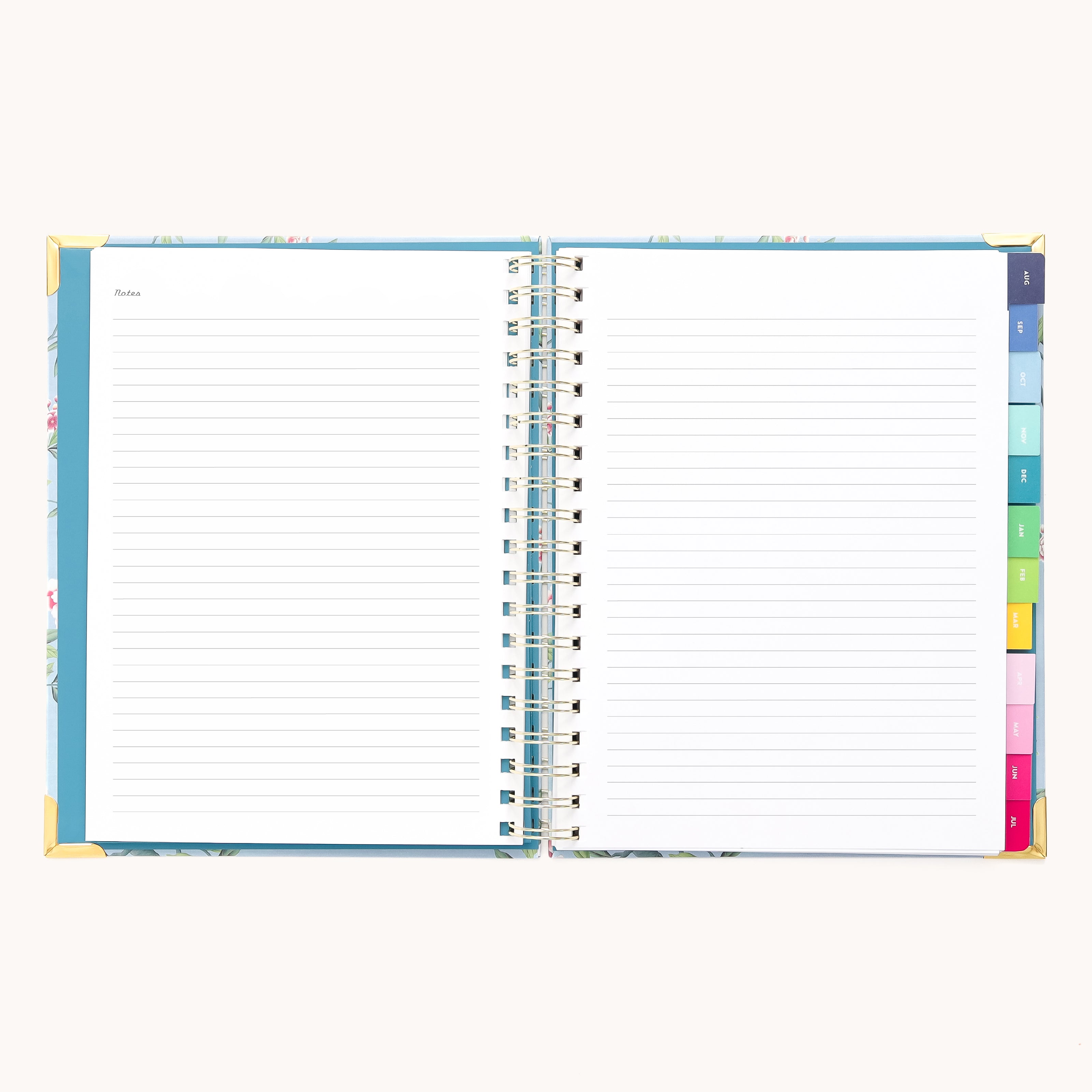 The 2025-2026 Spiral Weekly Simplified Planner - Faraway Land by Simplified is an elegant open spiral-bound notebook with lined pages and floral cover edges, gold foil accents, and colorful section tabs for organized notes.