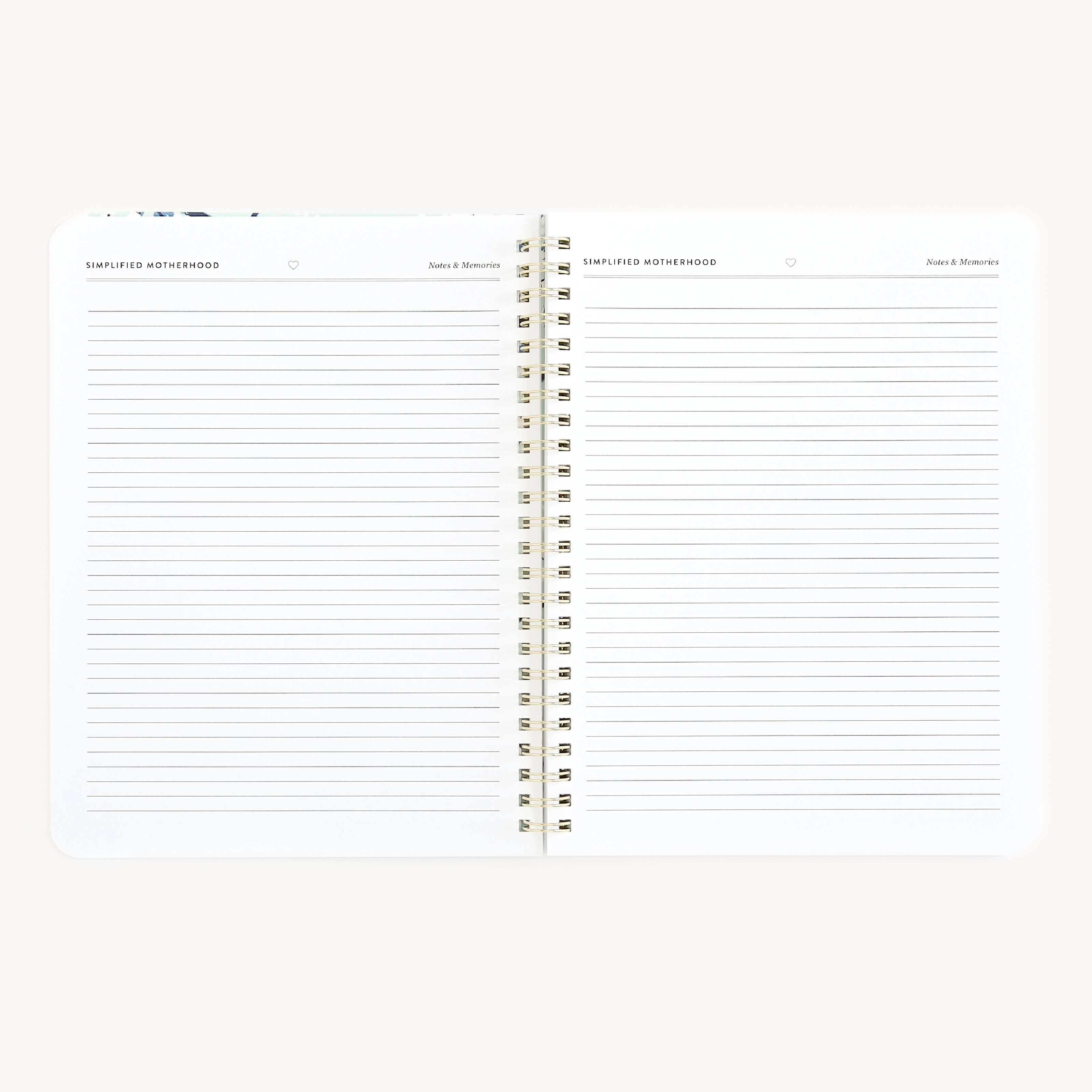 The Simplified Workbook - New Motherhood is an open spiral-bound notebook with lined pages. It offers busy parents space to organize thoughts, jot down dates, and capture memories on pages featuring lines and headers against a calm light gray background.