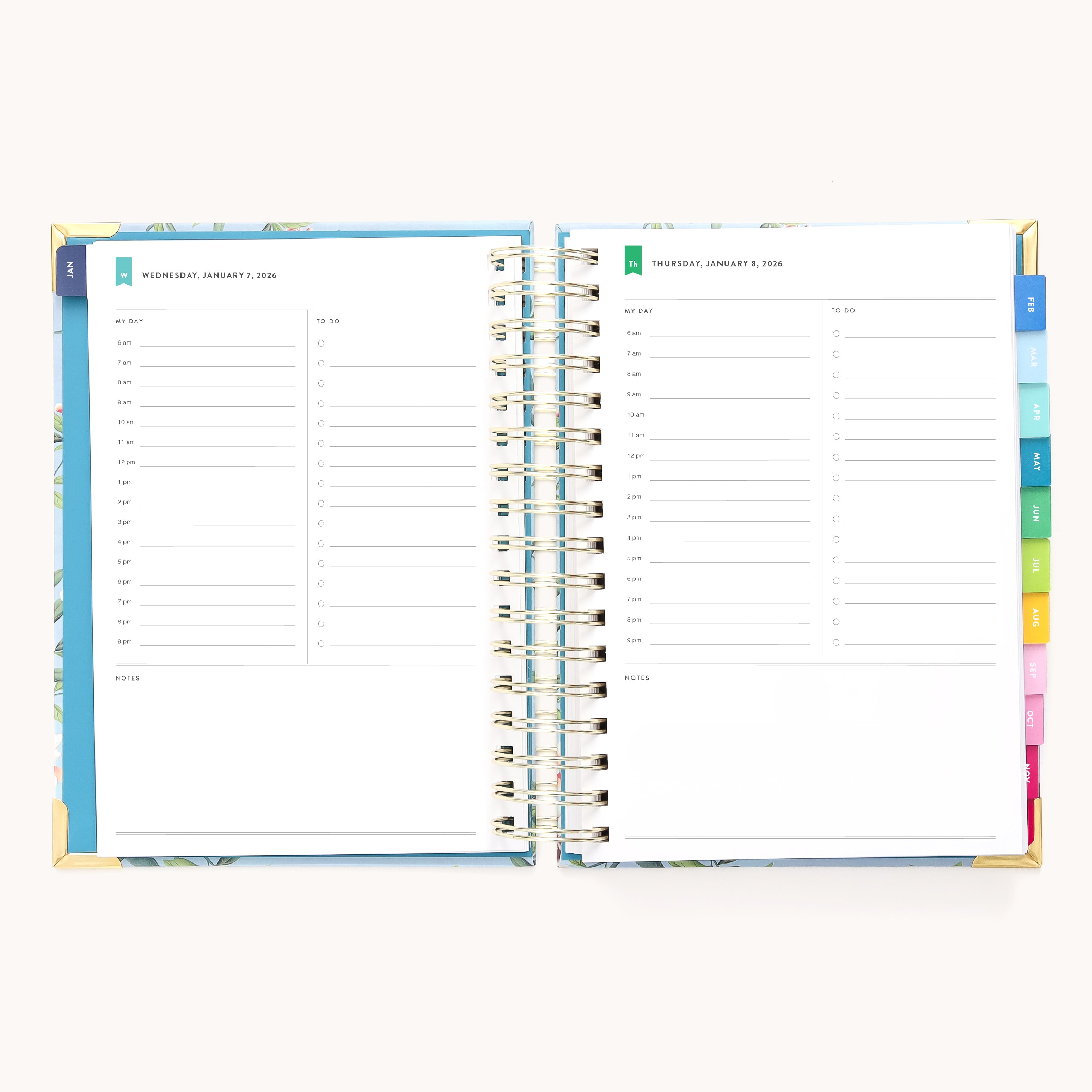 An open 2026 Spiral Daily Simplified Planner – Faraway Land by Simplified displays two daily pages with time slots from 6 a.m. to 7 p.m., notes sections, colorful side tabs, and a charming hand-painted pattern.