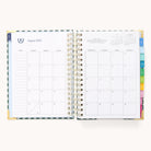 The 2025-2026 Spiral Daily Simplified Planner - Camp Gingham by Simplified offers a two-page spread for August 2025. The left page has weekly days with notes, and the right showcases a full month view. It features colorful tabbed dividers and subtle gold foil-detailed spiral binding for elegant flair.