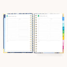 The 2025-2026 Spiral Daily Simplified Planner by Simplified, featuring gold foil and colorful tabbed dividers, is open to Wednesday, August 9, and Thursday, August 10, 2023. Each page offers hourly slots from 7 AM to 7 PM and includes a notes section below.