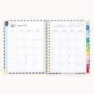 The 2025-2026 Spiral Weekly Simplified Planner - Camp Gingham by Simplified shows August 2025 with a monthly calendar on the right, space for notes on the left, plus elegant gold foil details and vibrant tabs marking different sections.