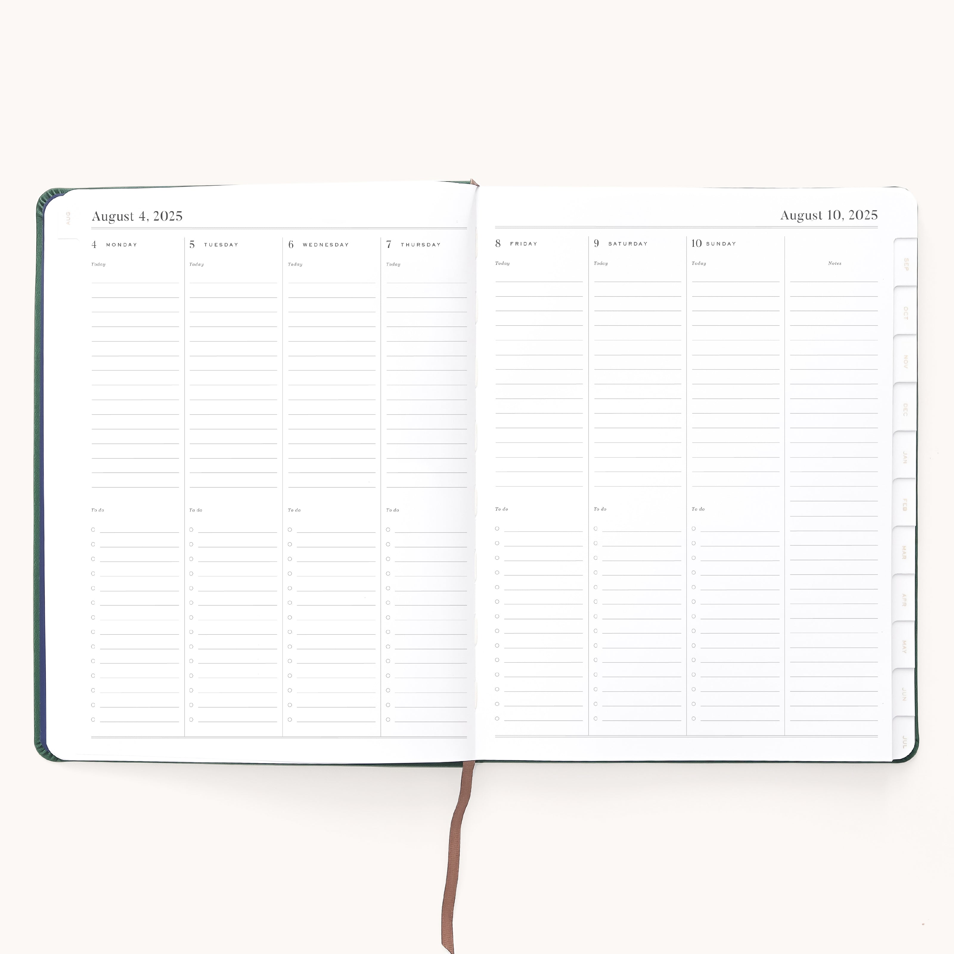 The Simplified 2025-2026 Bookbound Weekly Dapperdesk Planner in Evergreen, with a leatherette cover, features a layout from August 4 to August 10, 2025. Each days ruled sections accommodate time slots and notes, marked by a central brown ribbon bookmark.