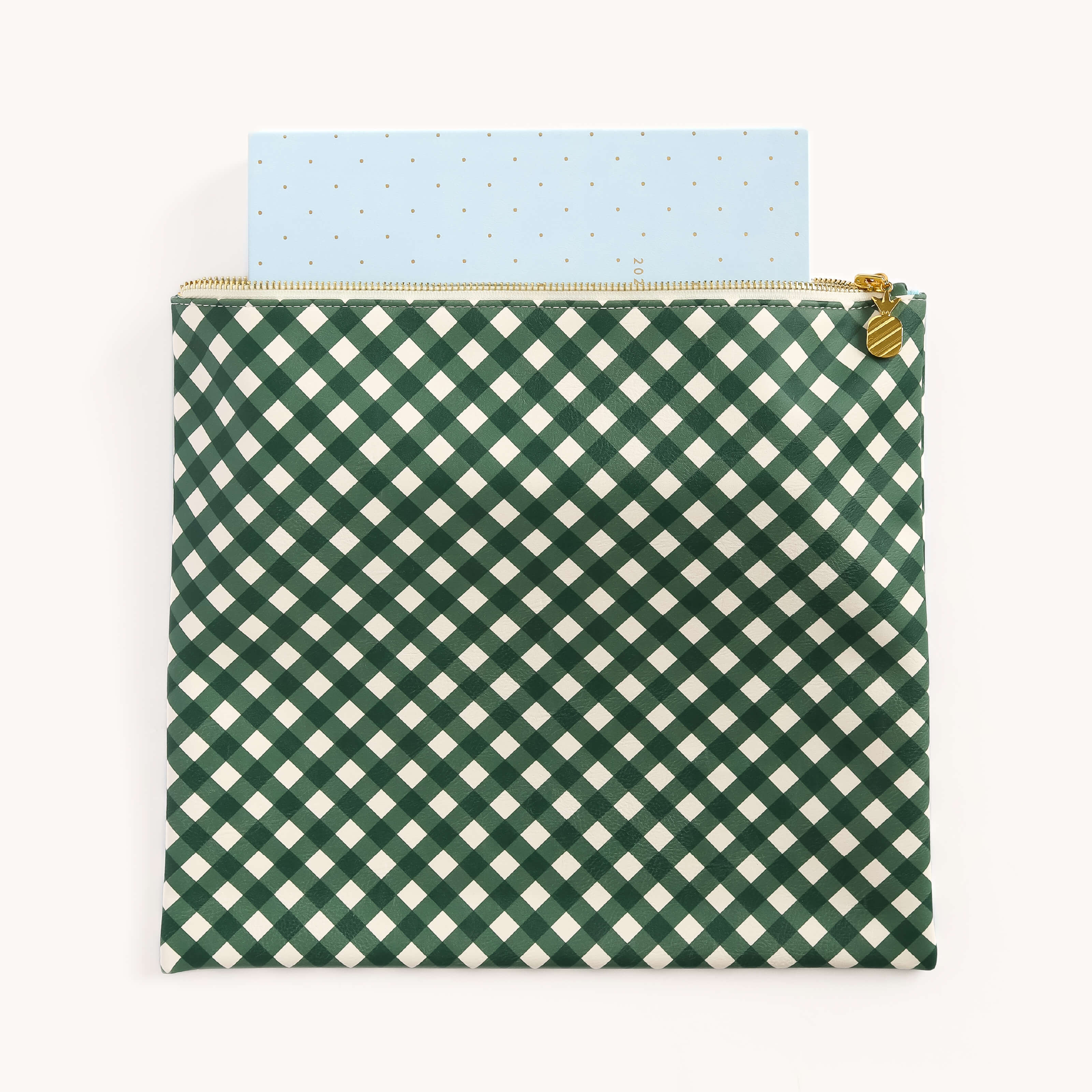 The Planner Pouch - Camp Gingham by Simplified offers a stylish storage solution with its green and white gingham pattern, leatherette exterior, and gold zipper. A blue rectangular object with dots peeks out from the top.