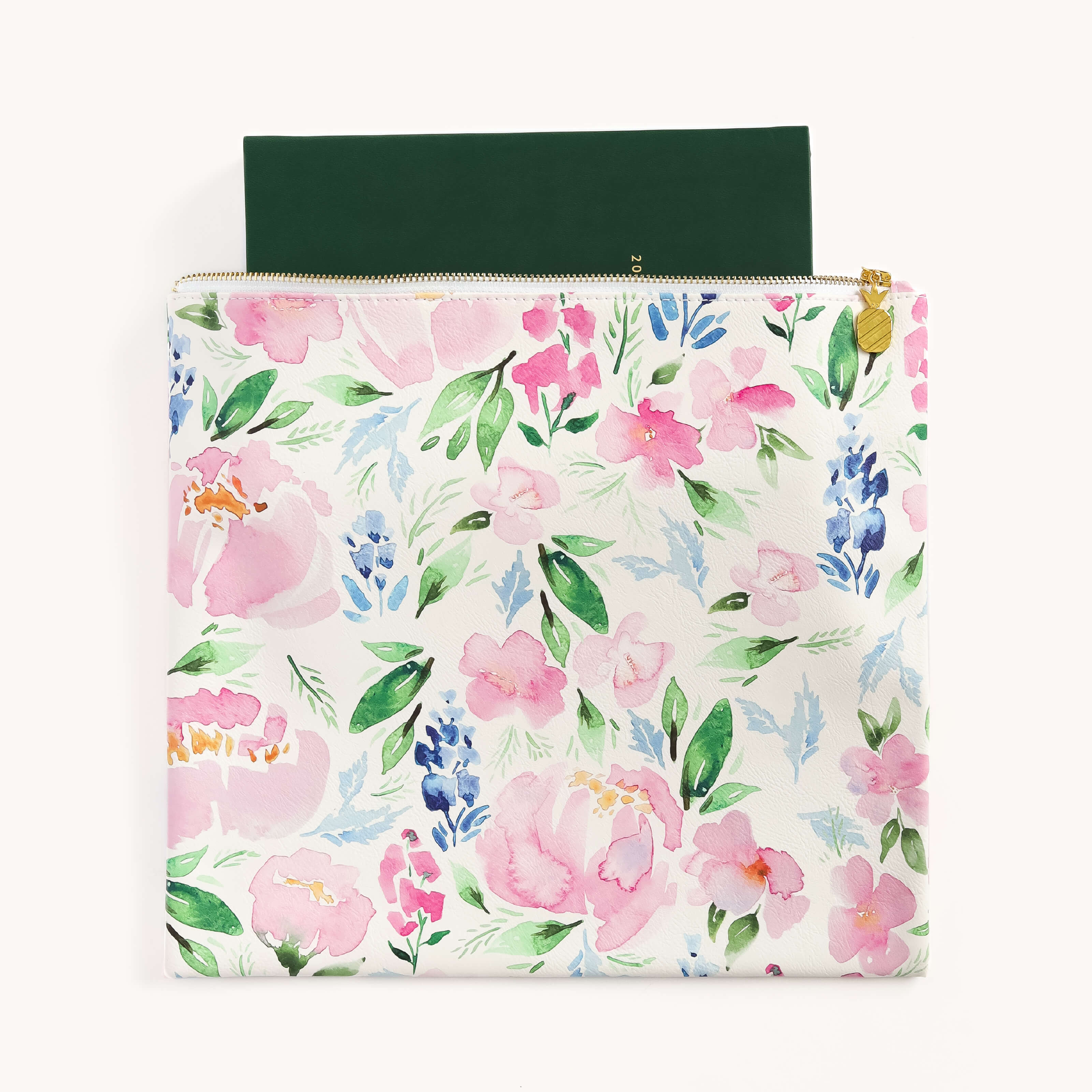 The Planner Pouch - Cottage Floral by Simplified offers a stylish storage solution with its watercolor floral design in pink, blue, and green hues. Partially unzipped against a white backdrop, it reveals a closed dark green notebook, blending beauty and function seamlessly.