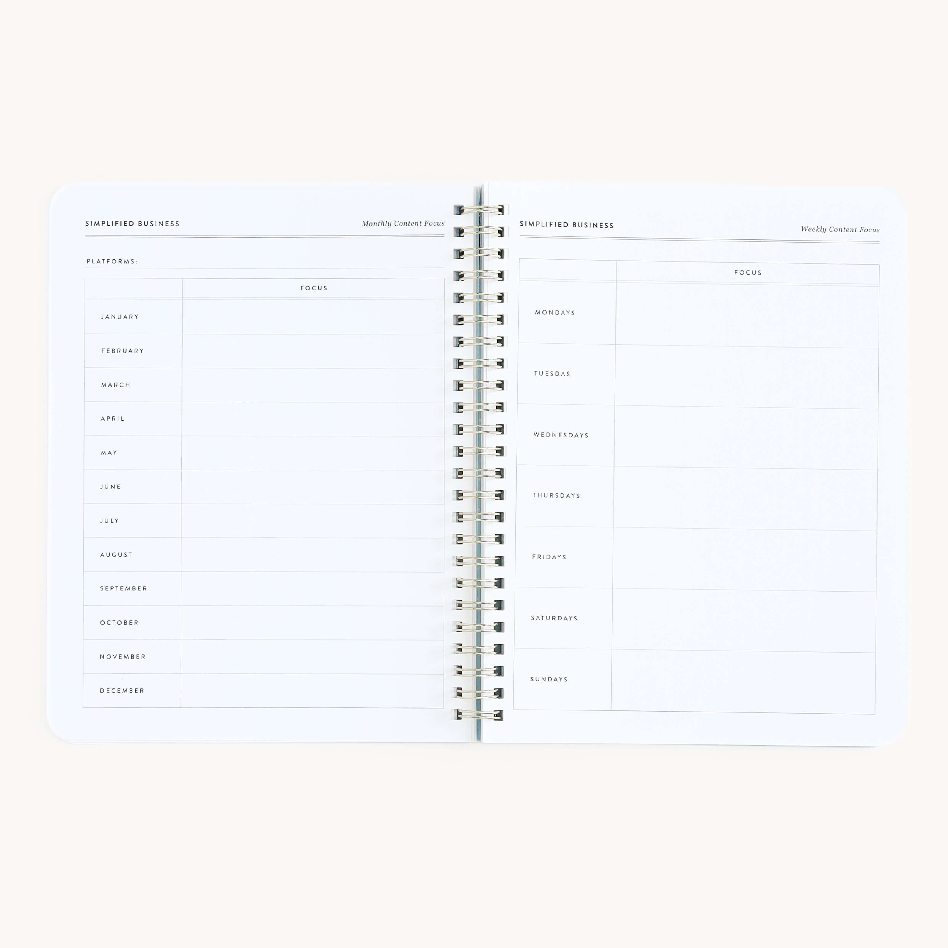 The Workbook - Entrepreneurship by Simplified displays an open planner: the left page is titled Monthly Content Focus with rows for months and columns for jotting down business ideas, while the right page is for Weekly Content Focus, featuring days of the week alongside planning routines, all neatly spiral-bound.