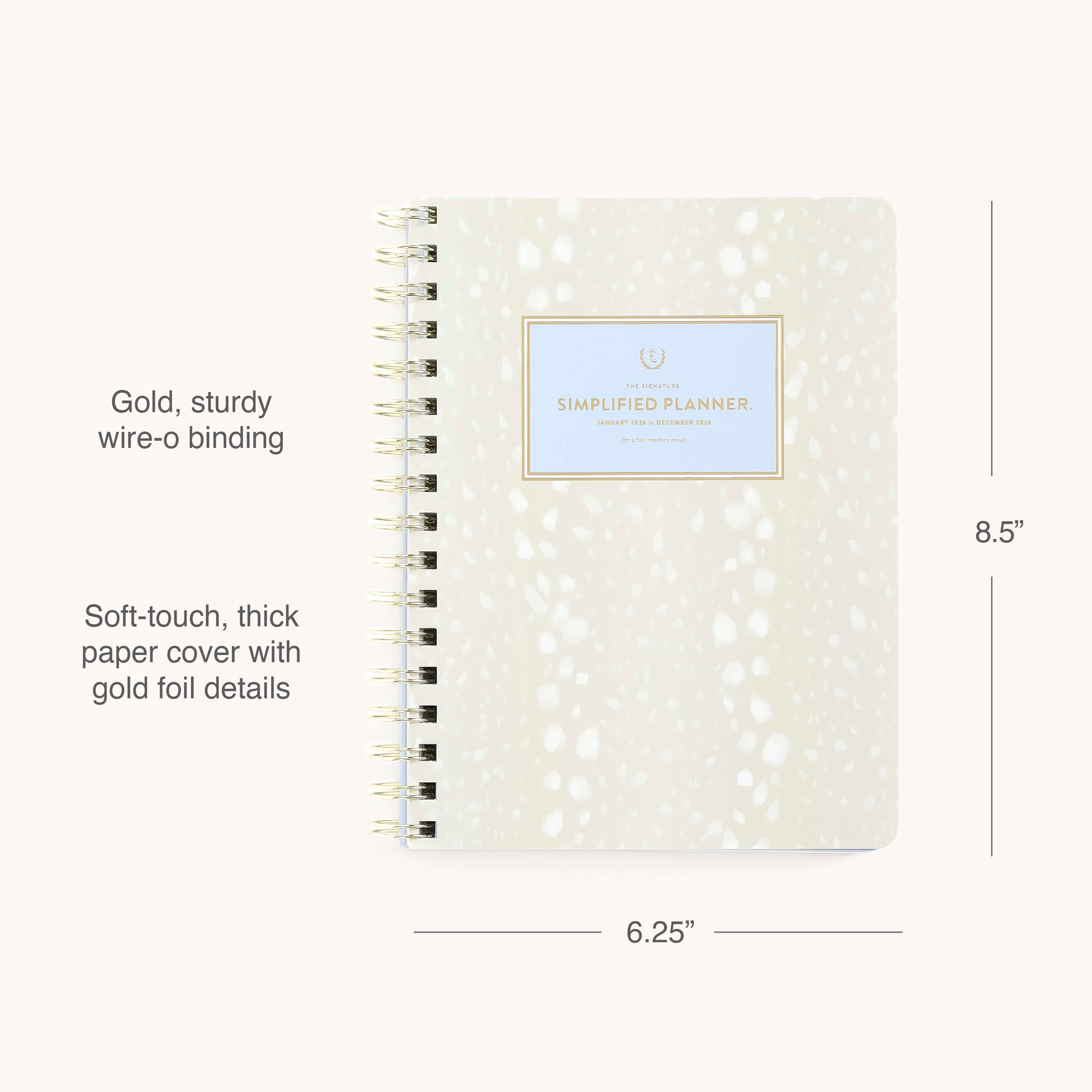 The Simplified 2026 Softcover Weekly Simplified Planner - Ivory Antelope features a beige soft-touch cover with white spots, gold wire-o binding, and a gold-foil label. This 12-month planner measures 8.5H x 6.25W.