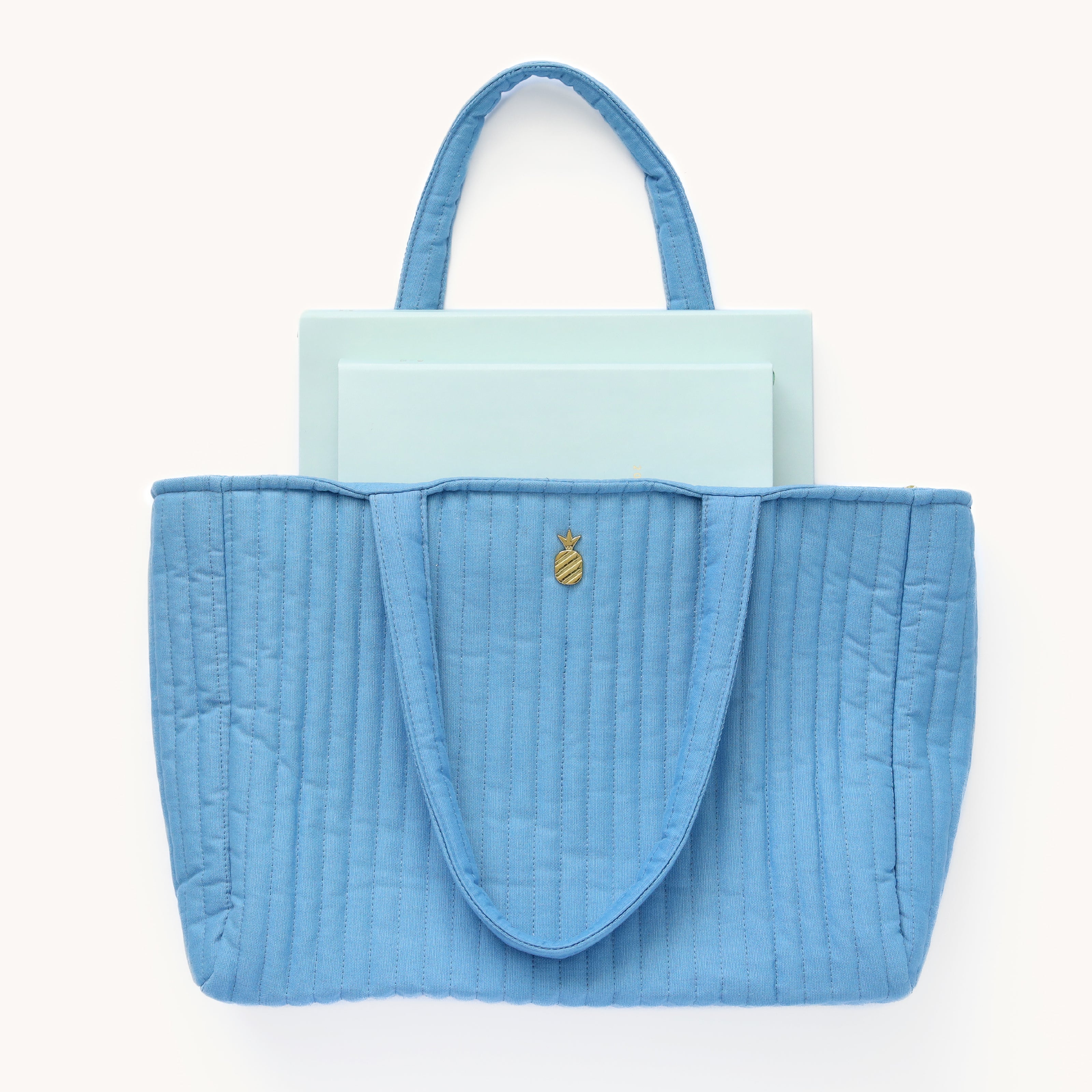 Weekly Dapperdesk Planner and Daily Dapperdesk Planner peeking out from the French Blue Quilted Tote Bag.