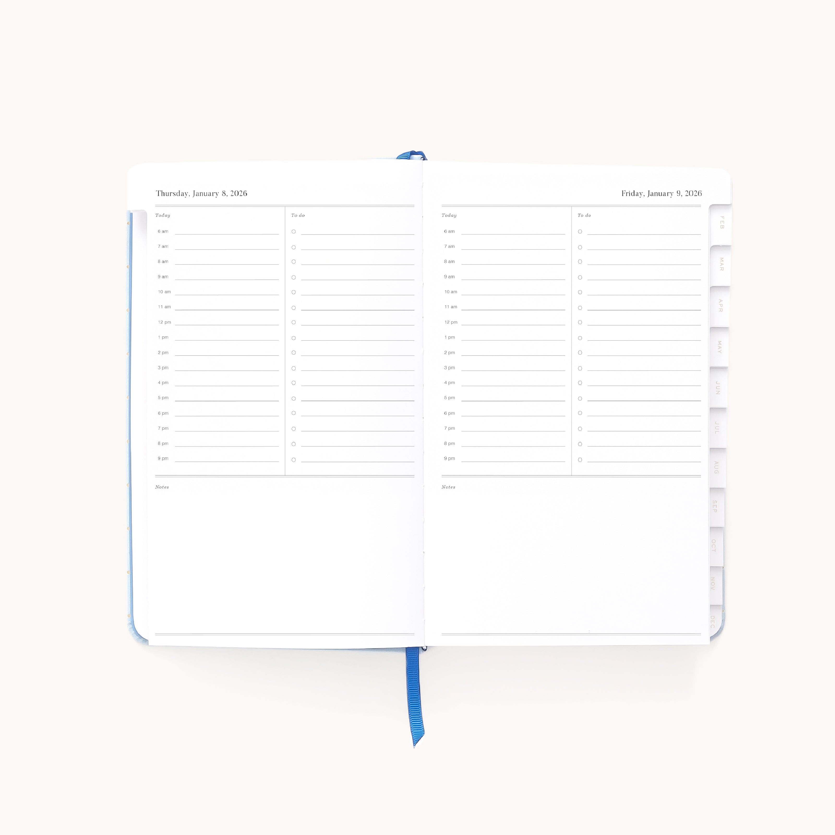 The Simplified 2026 Bookbound Daily Dapperdesk Planner - Carolina Dot features an open leatherette cover showing dated pages for Jan. 2-3, 2026, hourly schedules from 7 a.m.–8 p.m., note sections, and a blue ribbon bookmark.