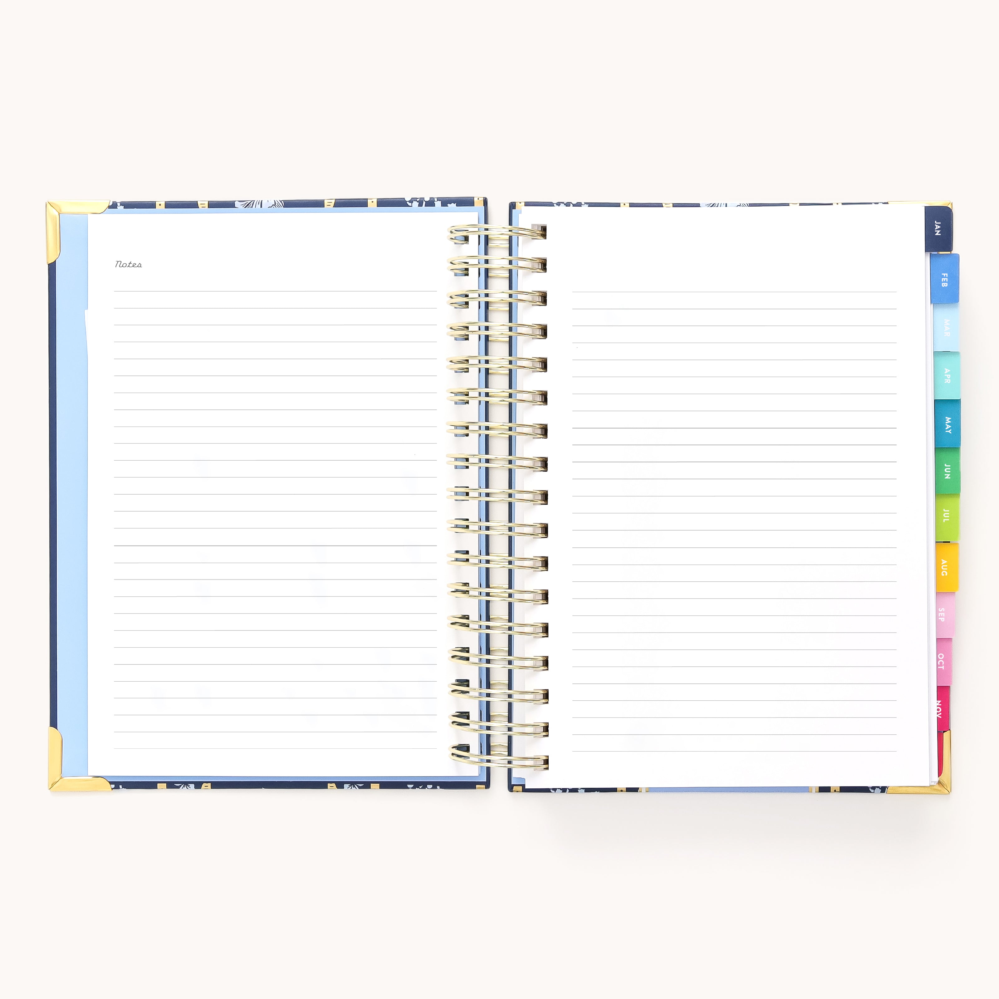 The 2026 Spiral Daily Simplified Planner - Poppy Posies by Simplified rests open on a light surface, featuring lined pages with Notes at the top and colorful tabbed dividers—perfect for organizing your schedule in style.