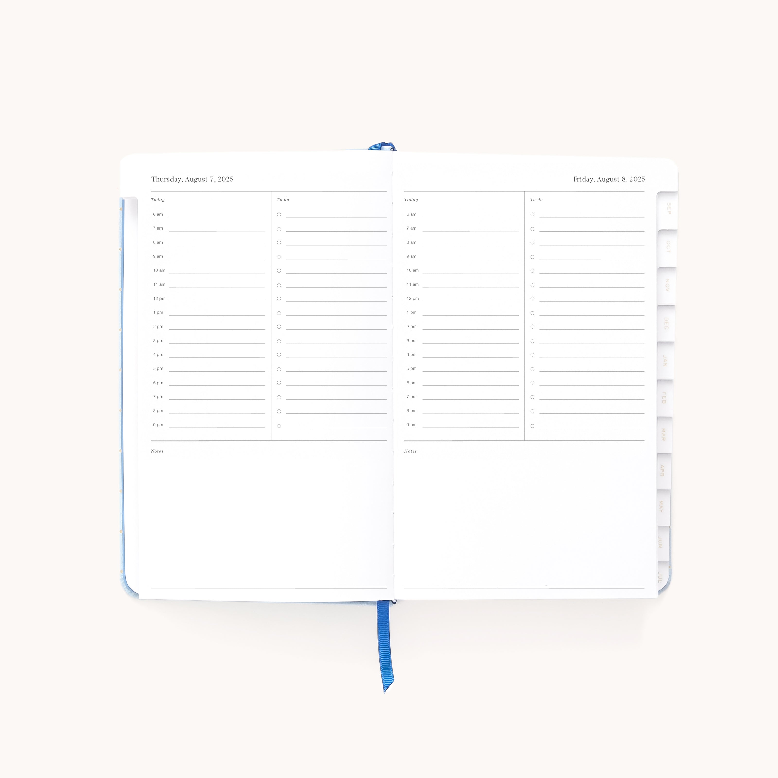 The 2025-2026 Bookbound Daily Dapperdesk Planner - Carolina Dot by Simplified is open, revealing a leatherette cover and a spread for Thursday, August 3, and Friday, August 4. The pages feature an hourly schedule from 7 AM to 8 PM plus a notes section and a centered blue ribbon bookmark.
