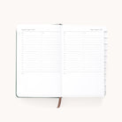 The 2025-2026 Bookbound Daily Dapperdesk Planner - Evergreen by Simplified showcases a two-page spread for August 8 and 9, 2025, with vertical hourly lists from 7 AM to 9 PM and lined spaces for notes. It features a durable bookbound cover and visible tabs on the right edge for easy navigation.