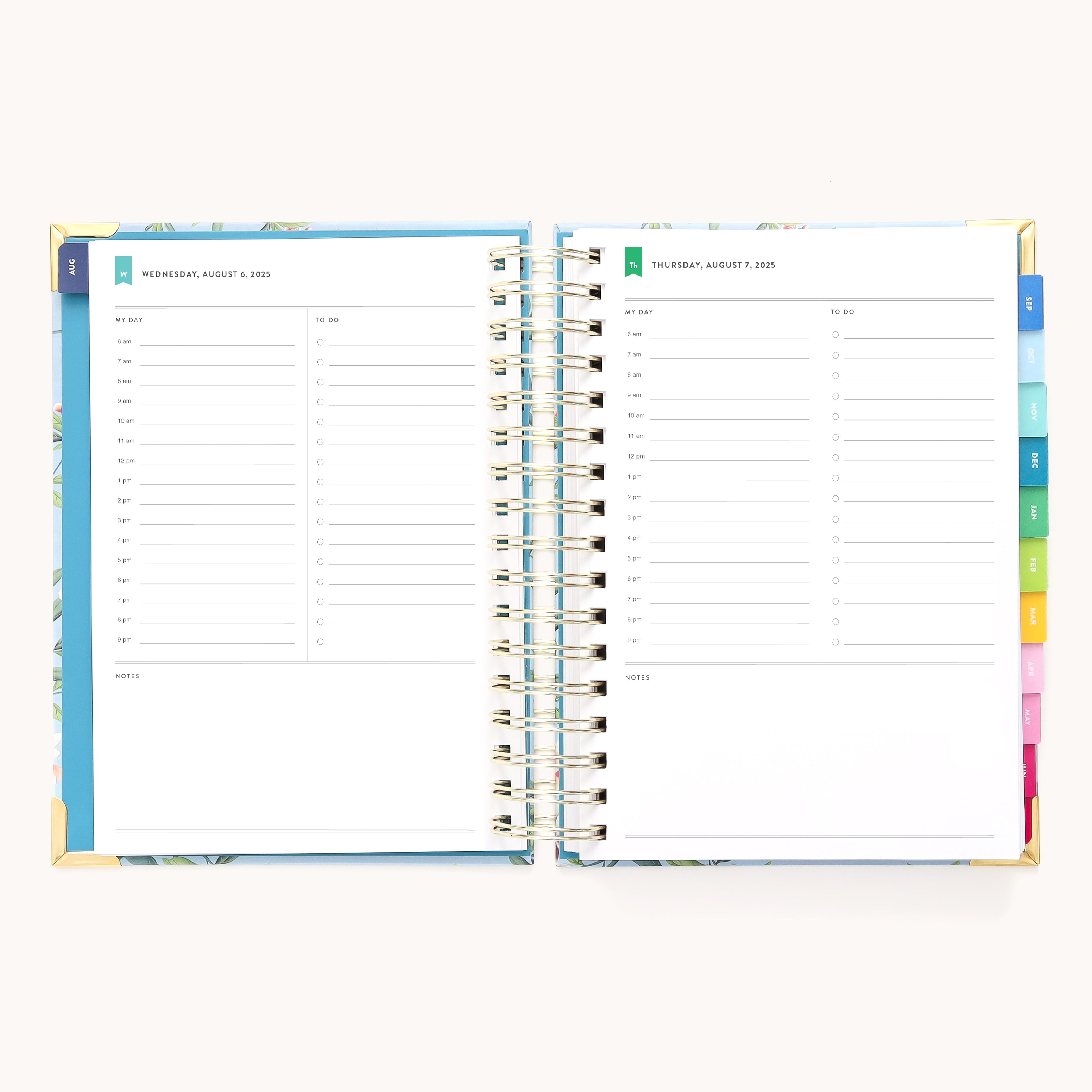 The 2025-2026 Spiral Daily Simplified Planner - Faraway Land by Simplified is open on a light background, showcasing gold foil details, dated sections for Wednesday and Thursday with hourly lines from 7 AM to 7 PM, colorful tabbed dividers on the right, and space for notes at the bottom.