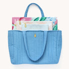 Blush Magnolia Tech Case, Pink Gingham Planner Pouch, and Grace Not Perfection Pencil Pouch peeking out from French Blue Quilted Tote Bag.