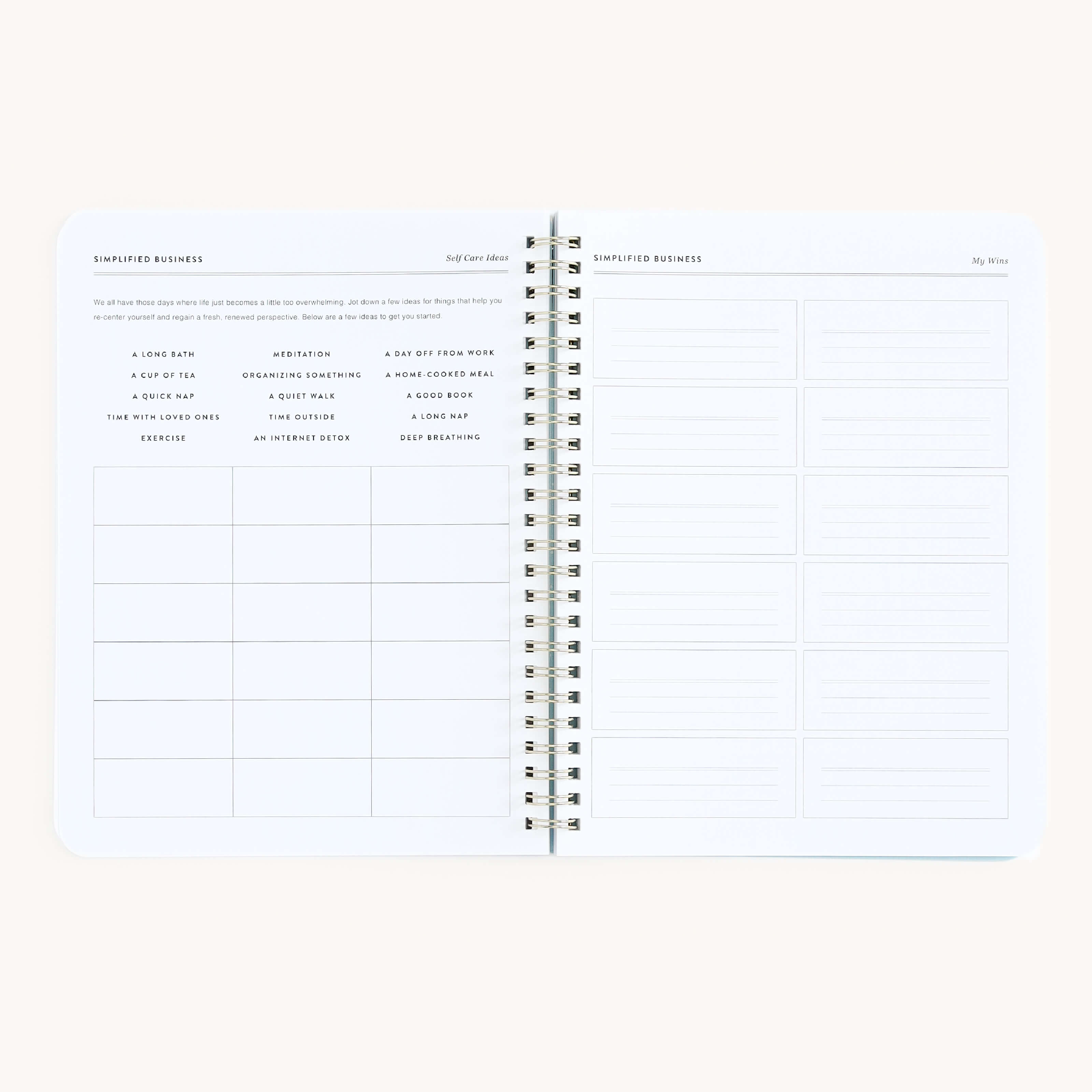 An open Simplified spiral notebook shows a grid layout on the left page titled Simplified Business Ideas, with columns for ideas and notes. The right page, resembling the Workbook - Entrepreneurship, includes empty rectangles for planning routines.