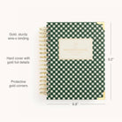 The 2026 Spiral Daily Simplified Planner - Camp Gingham by Simplified features a green and white plaid cover, gold wire-o binding, gold foil details, protective corners, and measures 9.2 x 6.8—perfect for stylish organization.