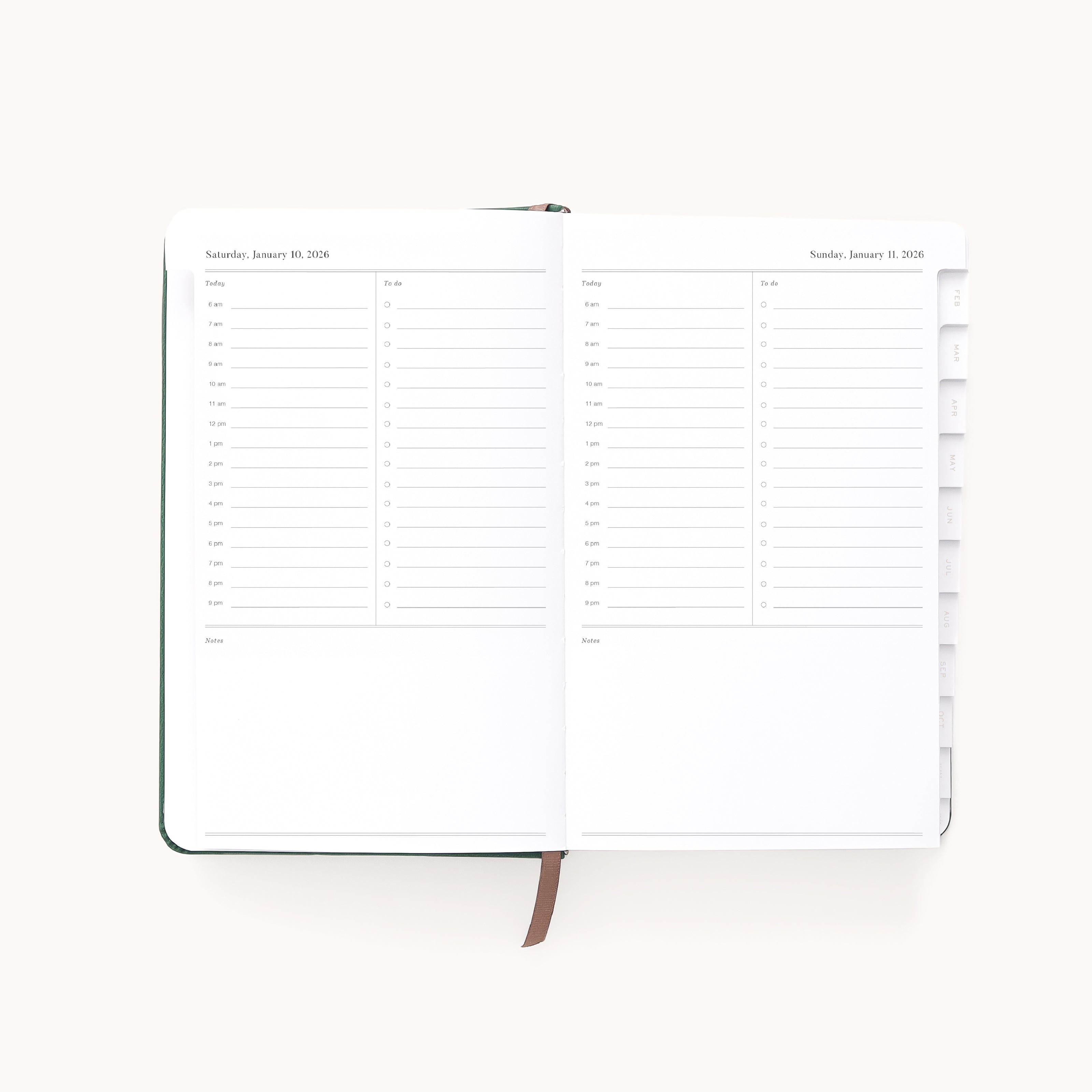 The Simplified 2026 Bookbound Daily Dapperdesk Planner in Evergreen shows two pages with hourly schedules for Saturday and Sunday. It features a leatherette cover, brown ribbon bookmark, and tabbed dividers on the right.