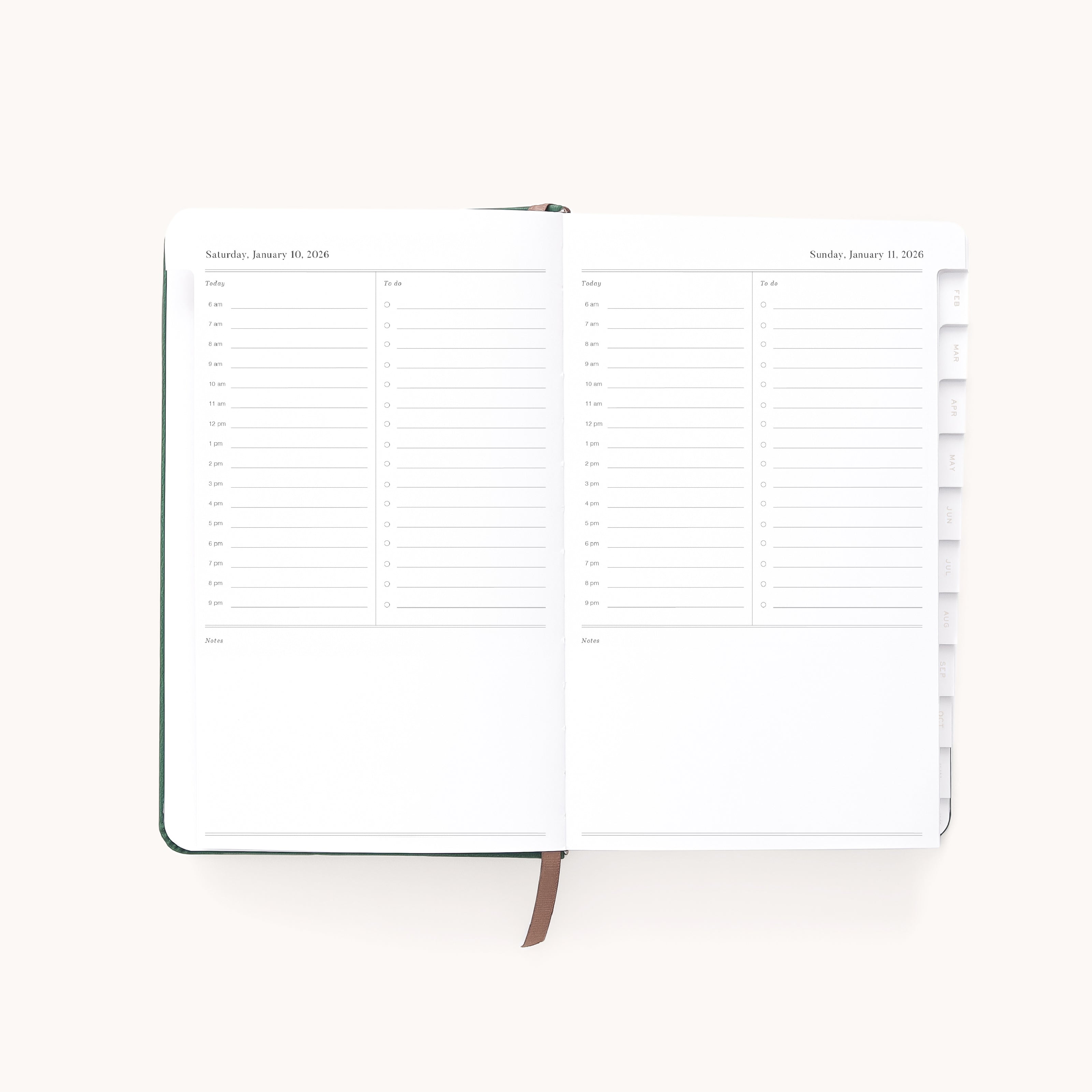The Simplified 2026 Bookbound Daily Dapperdesk Planner in Evergreen shows two pages with hourly schedules for Saturday and Sunday. It features a leatherette cover, brown ribbon bookmark, and tabbed dividers on the right.