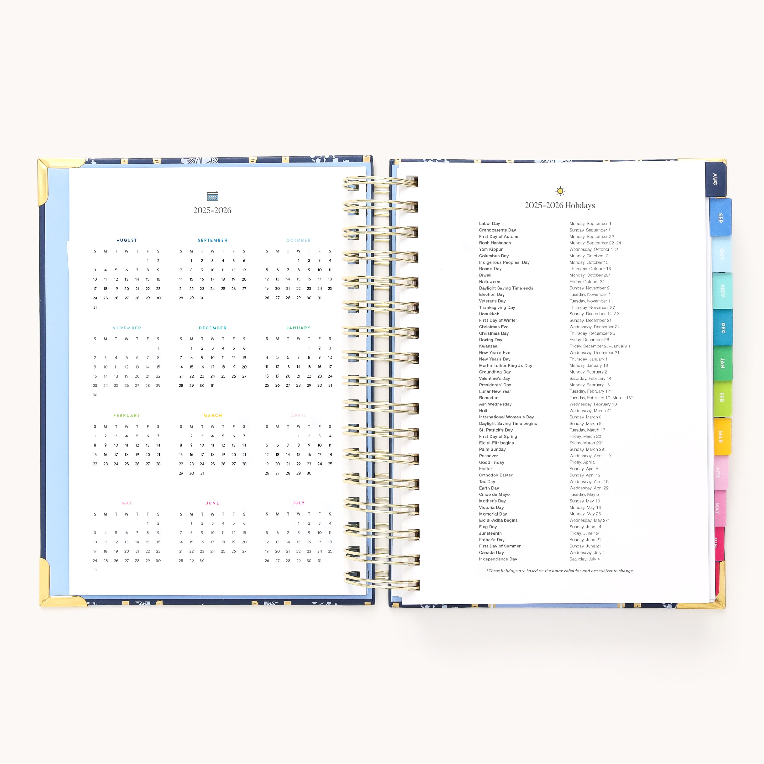 The 2025-2026 Spiral Daily Simplified Planner - Poppy Posies by Simplified features gold foil details, an open layout with a calendar on the left and holidays on the right. Spiral-bound with colorful tabs, it rests on a plain white background, making your planning elegant and efficient.